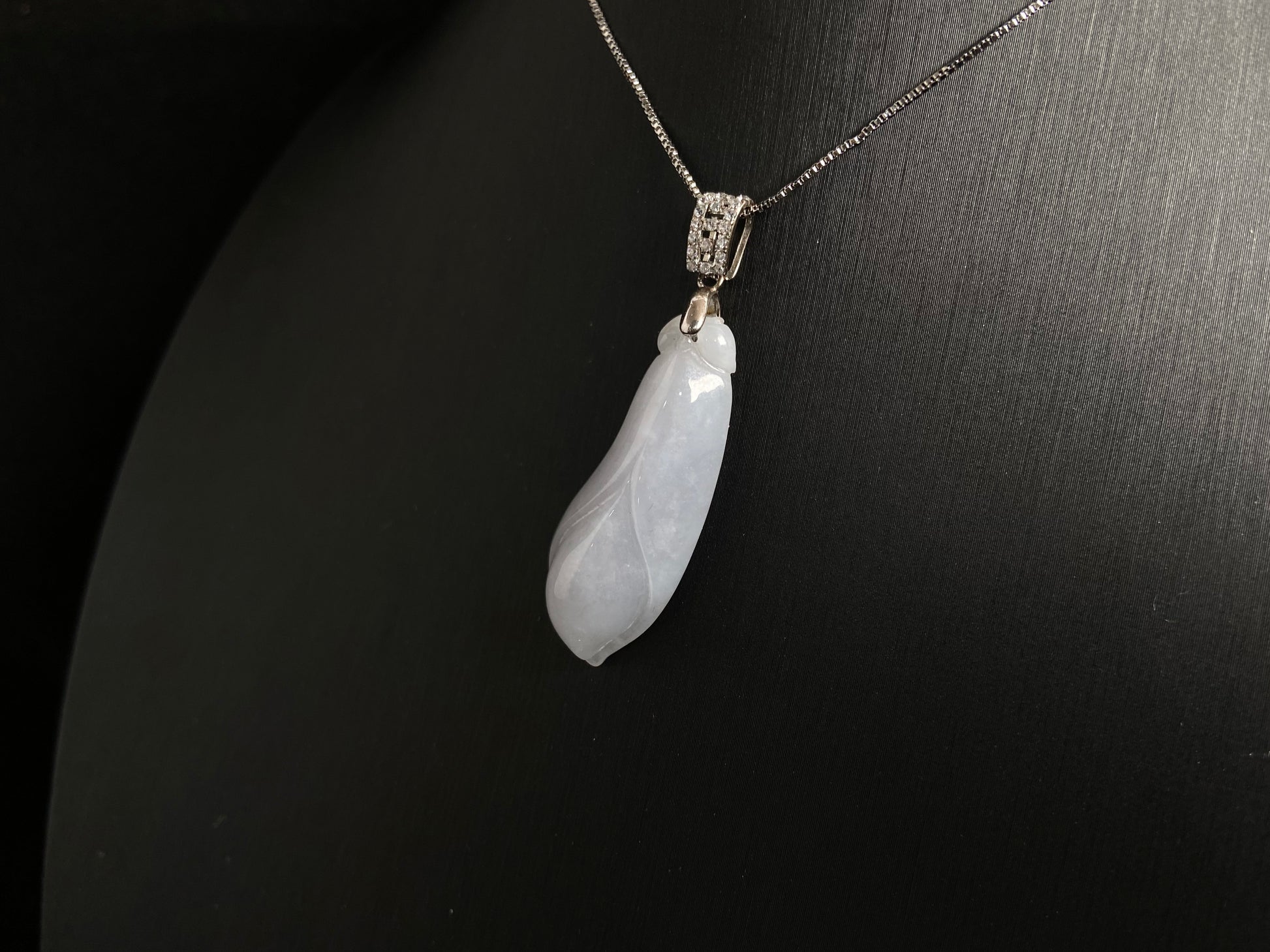 A milky white jade orchid blossom pendant, elegant and pure in its simplicity.