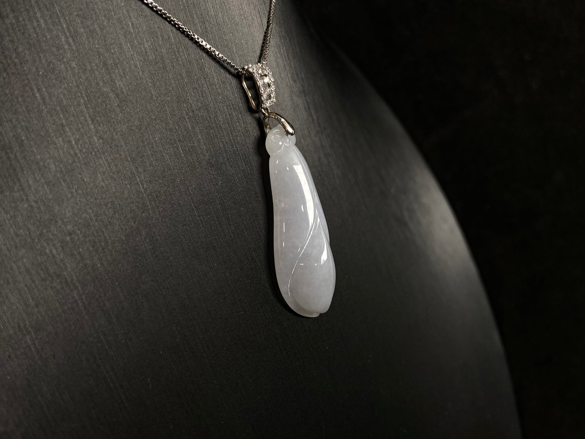 A milky white jade orchid blossom pendant, elegant and pure in its simplicity.