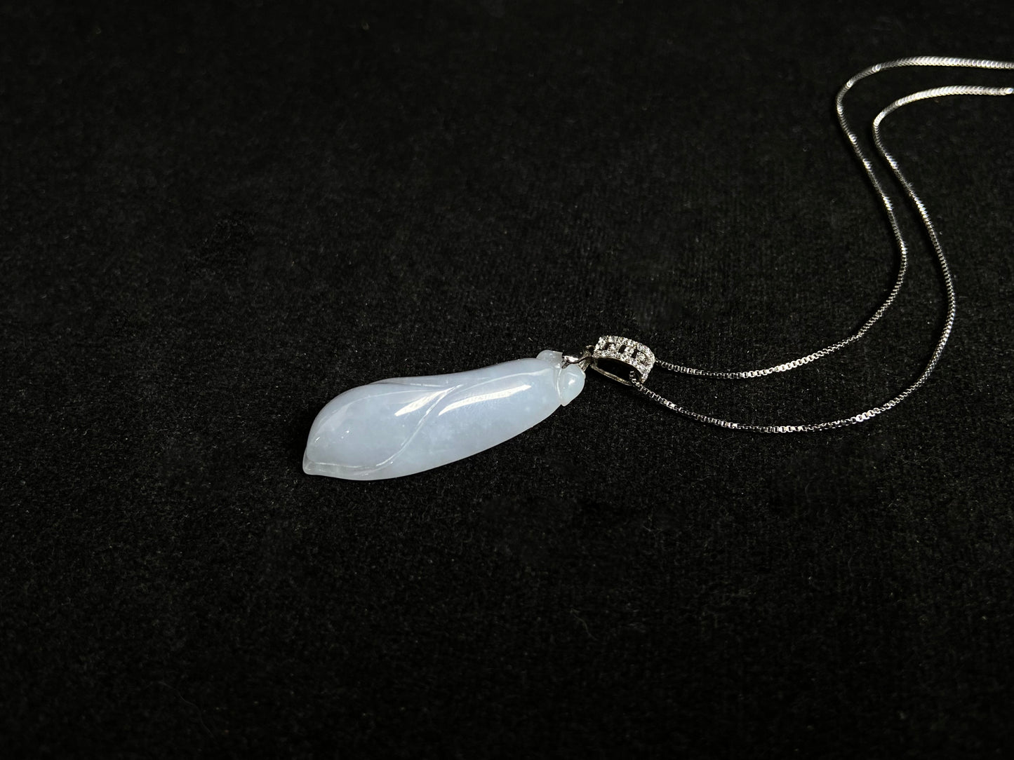 A milky white jade orchid blossom pendant, elegant and pure in its simplicity.