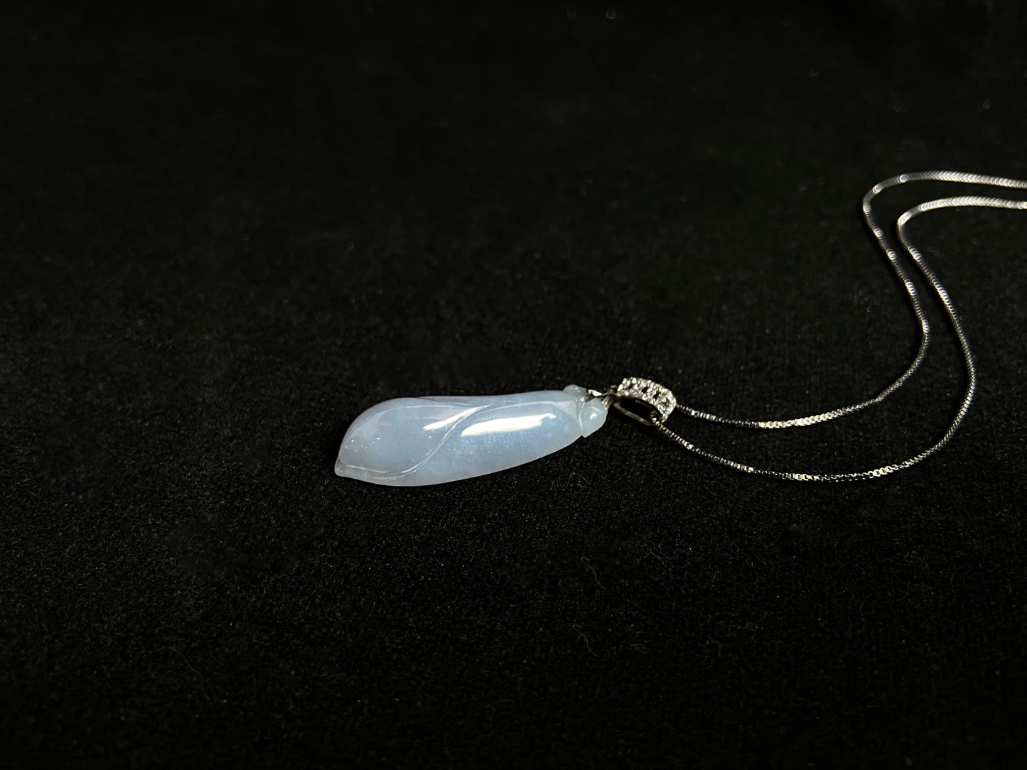 A milky white jade orchid blossom pendant, elegant and pure in its simplicity.