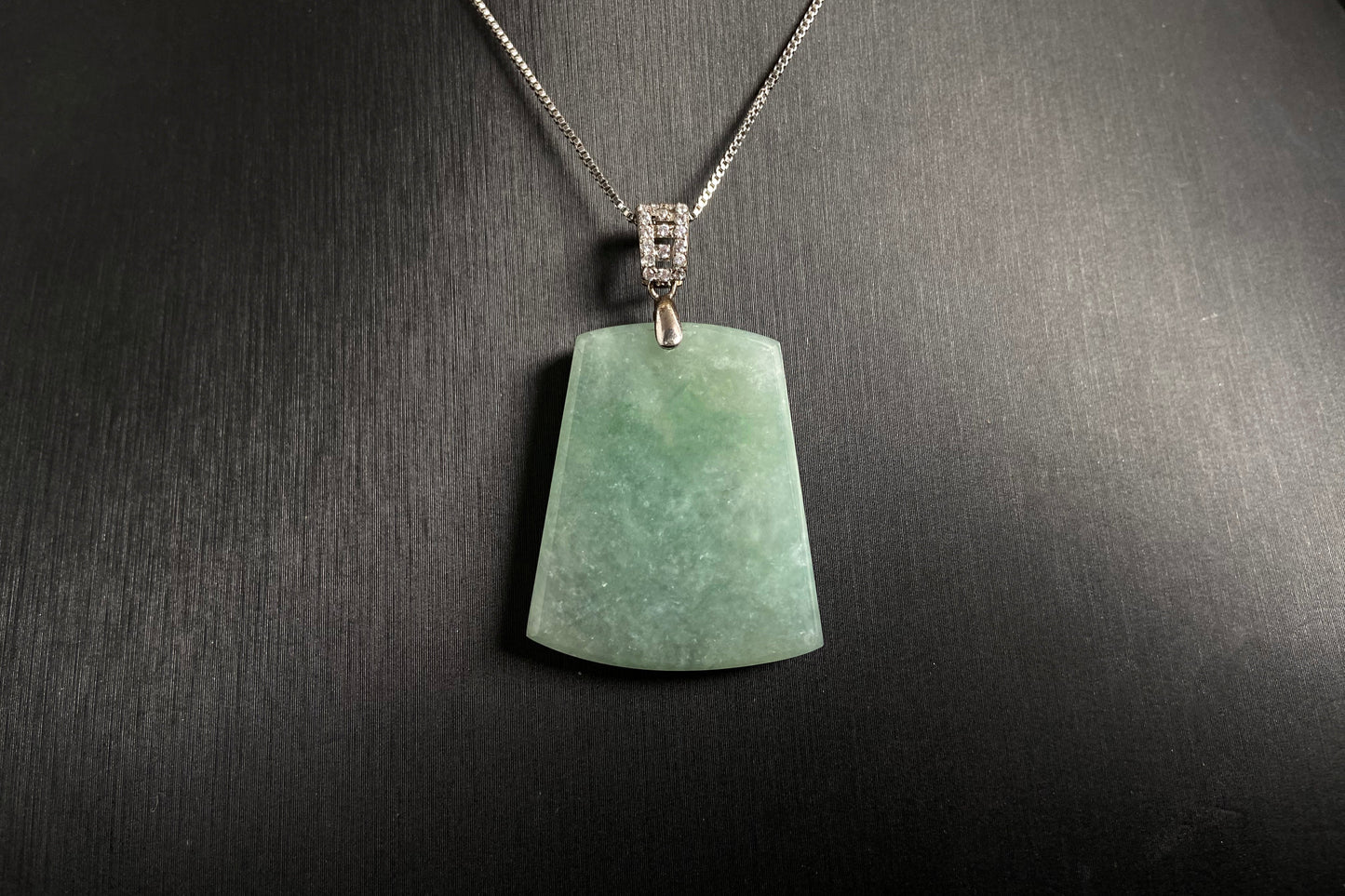 A pale greenish white jade plaque, perfectly plain and polished smooth.