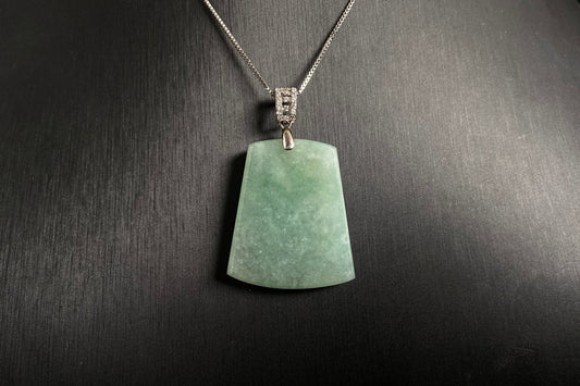 A pale greenish white jade plaque, perfectly plain and polished smooth.