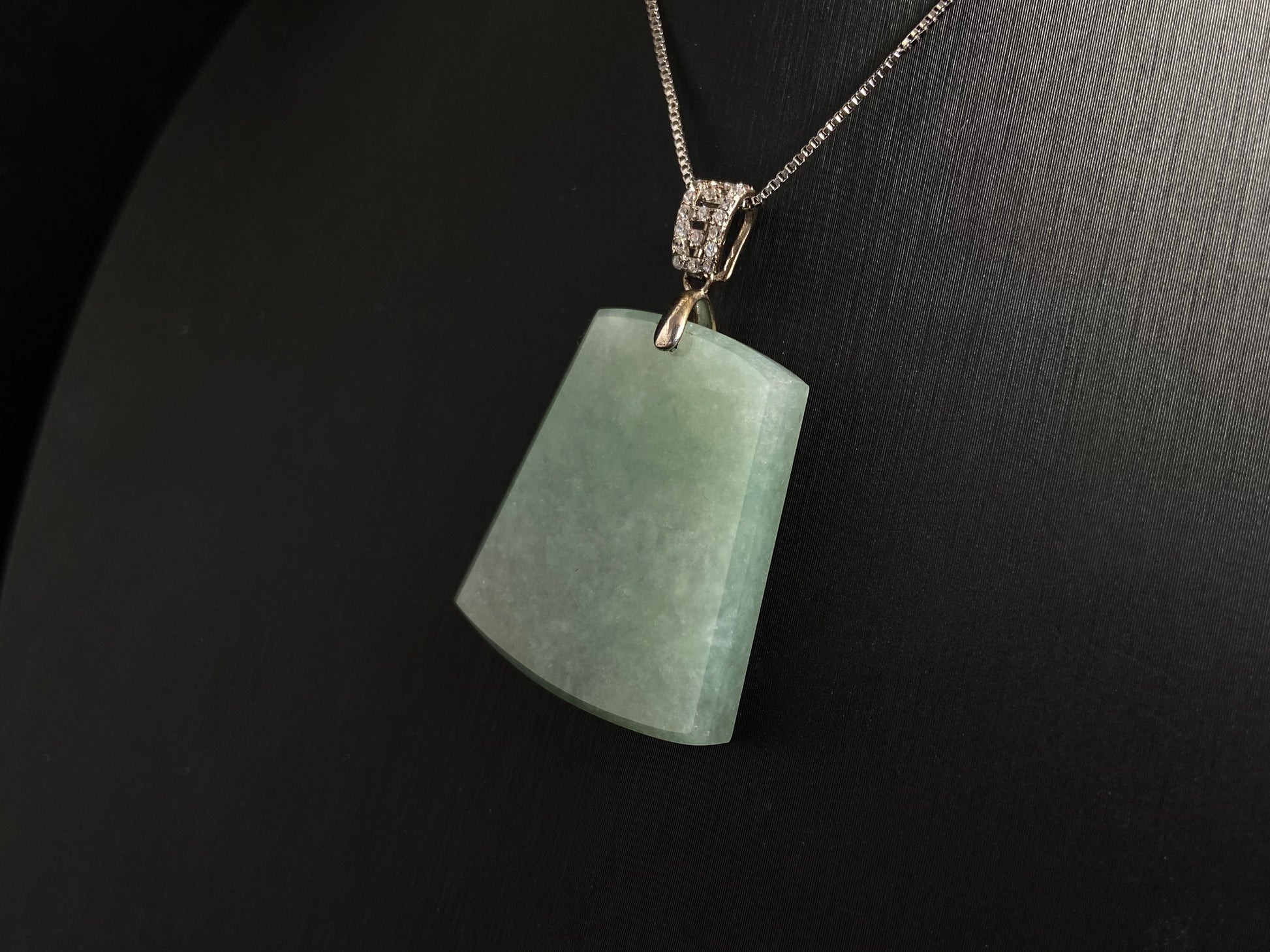 A pale greenish white jade plaque, perfectly plain and polished smooth.