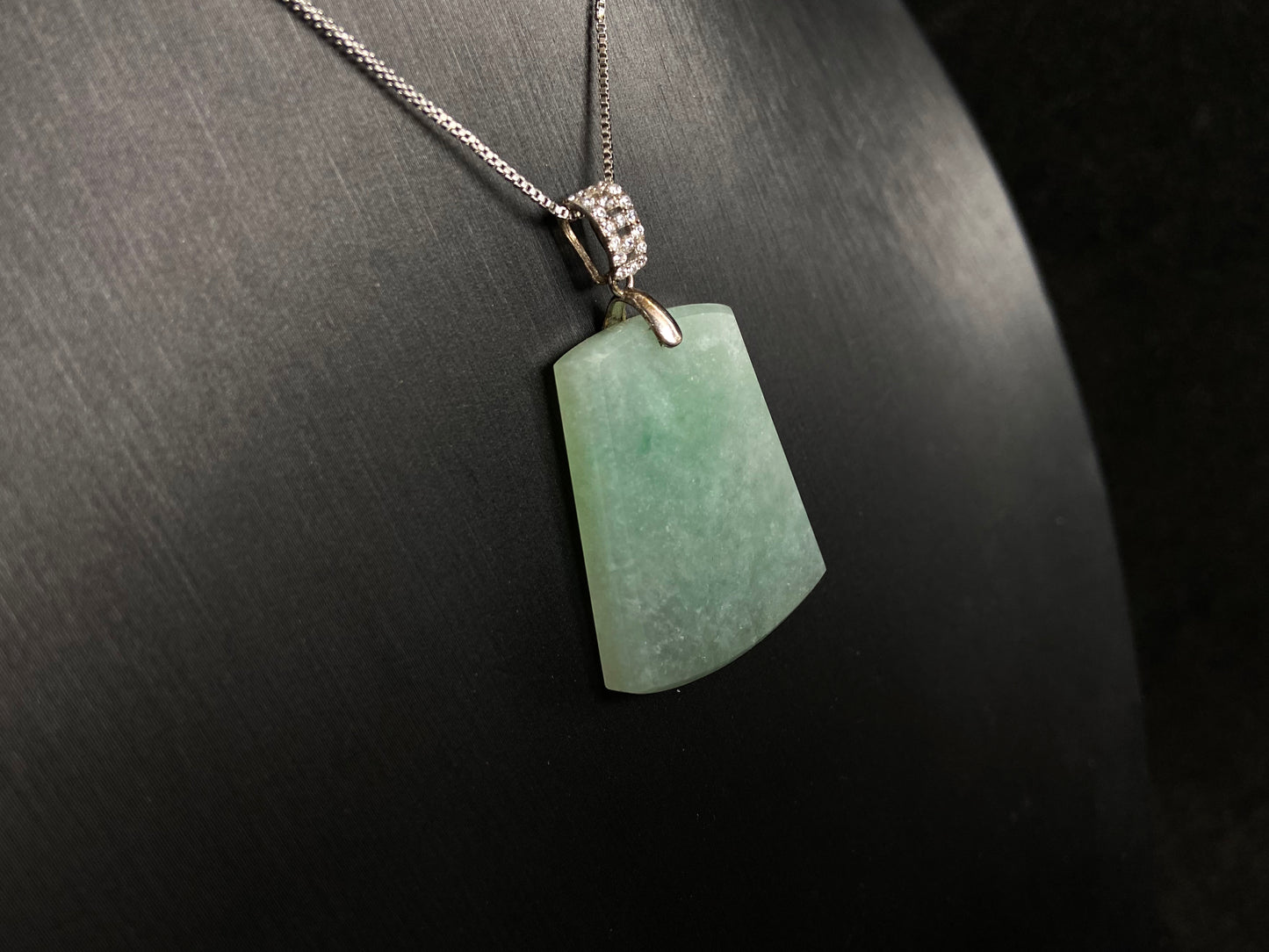 A pale greenish white jade plaque, perfectly plain and polished smooth.