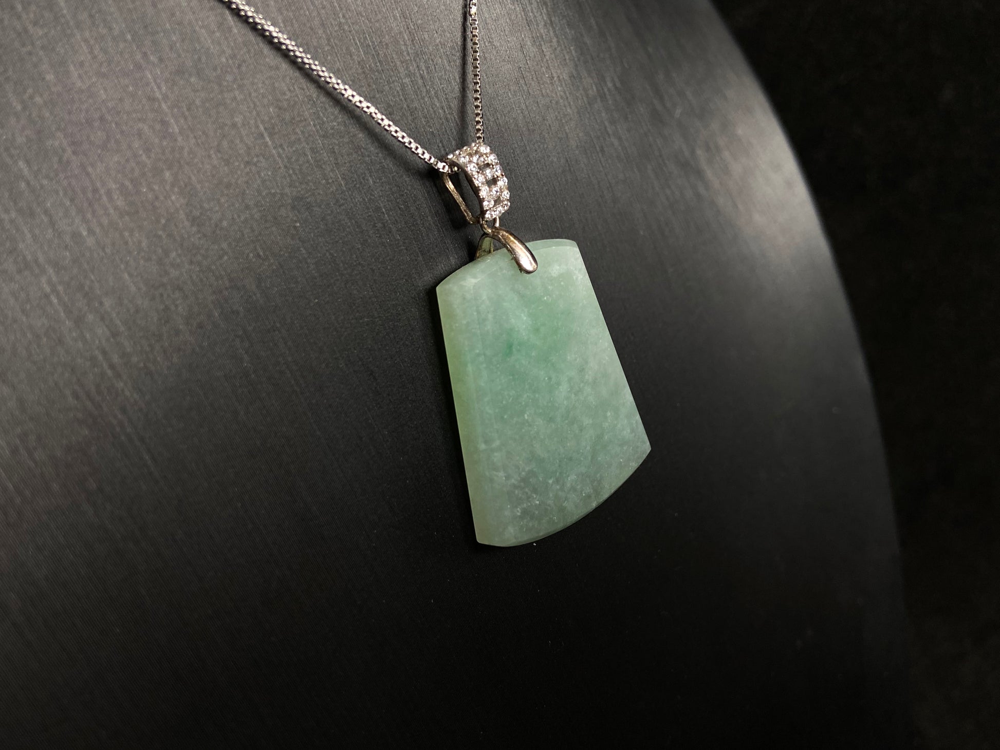 A pale greenish white jade plaque, perfectly plain and polished smooth.