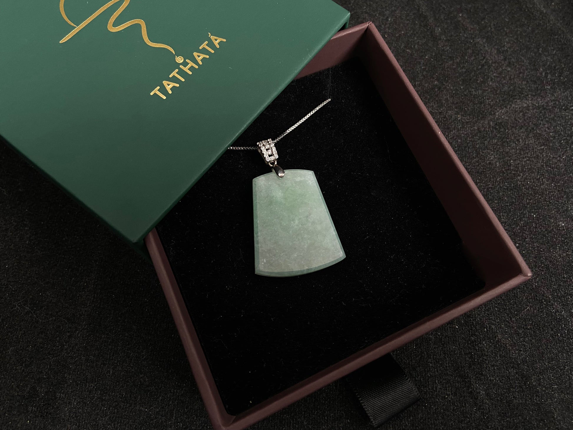 A pale greenish white jade plaque, perfectly plain and polished smooth.