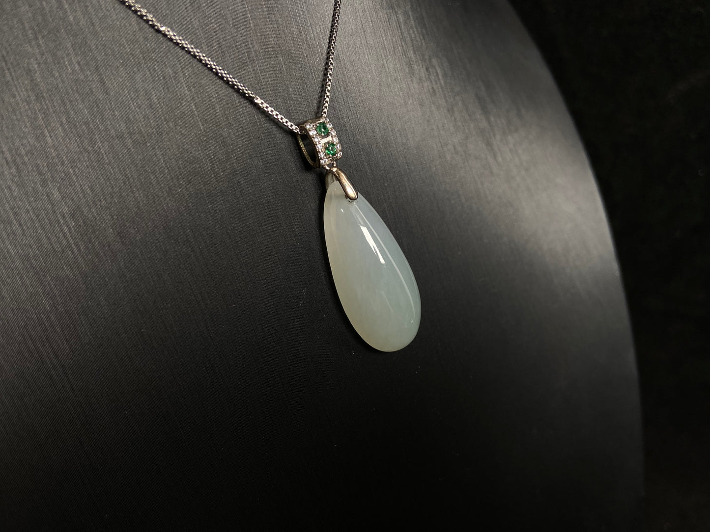 A translucent, milky white jade pendant crafted in a graceful teardrop shape.