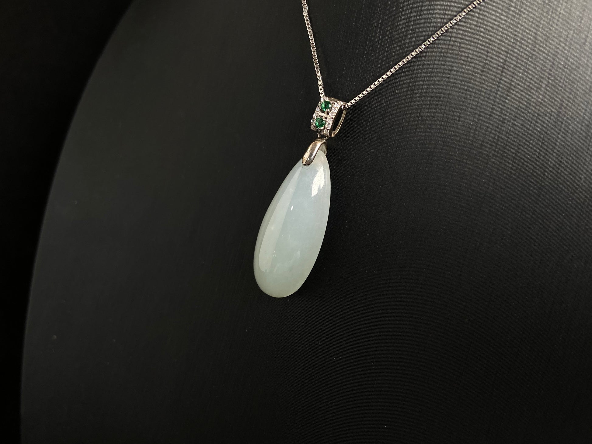 A translucent, milky white jade pendant crafted in a graceful teardrop shape.