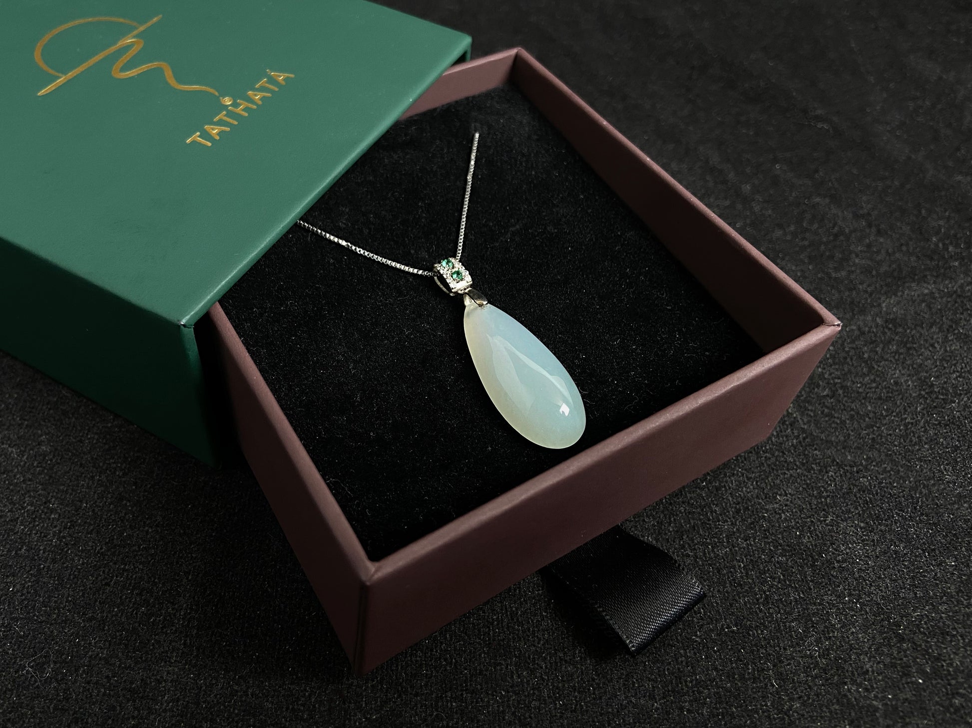 A translucent, milky white jade pendant crafted in a graceful teardrop shape.