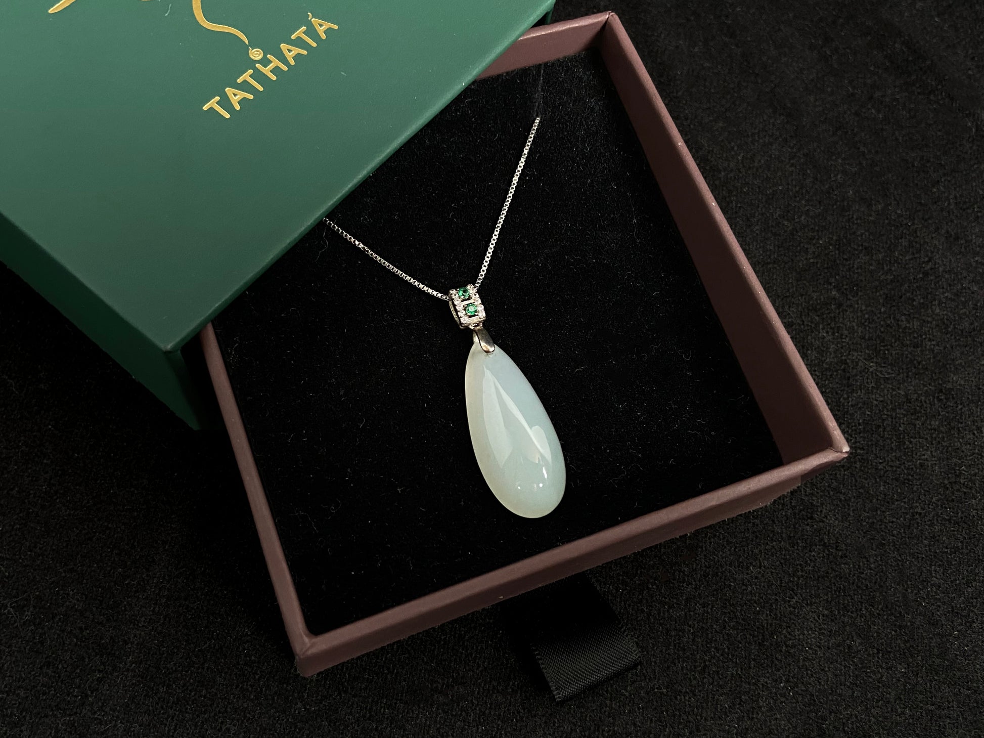 A translucent, milky white jade pendant crafted in a graceful teardrop shape.