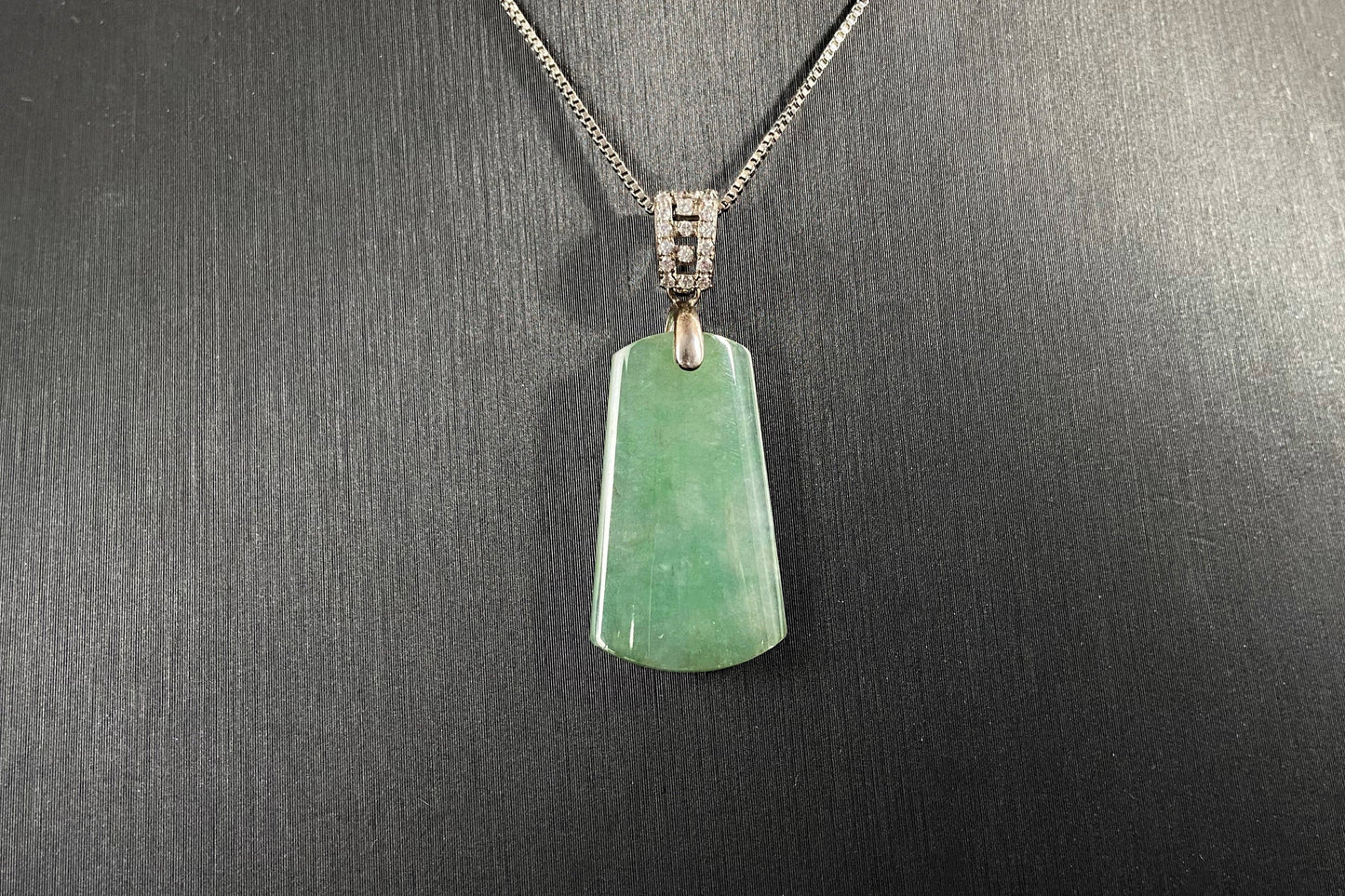This jade pendant is a peace plaque with a green base.