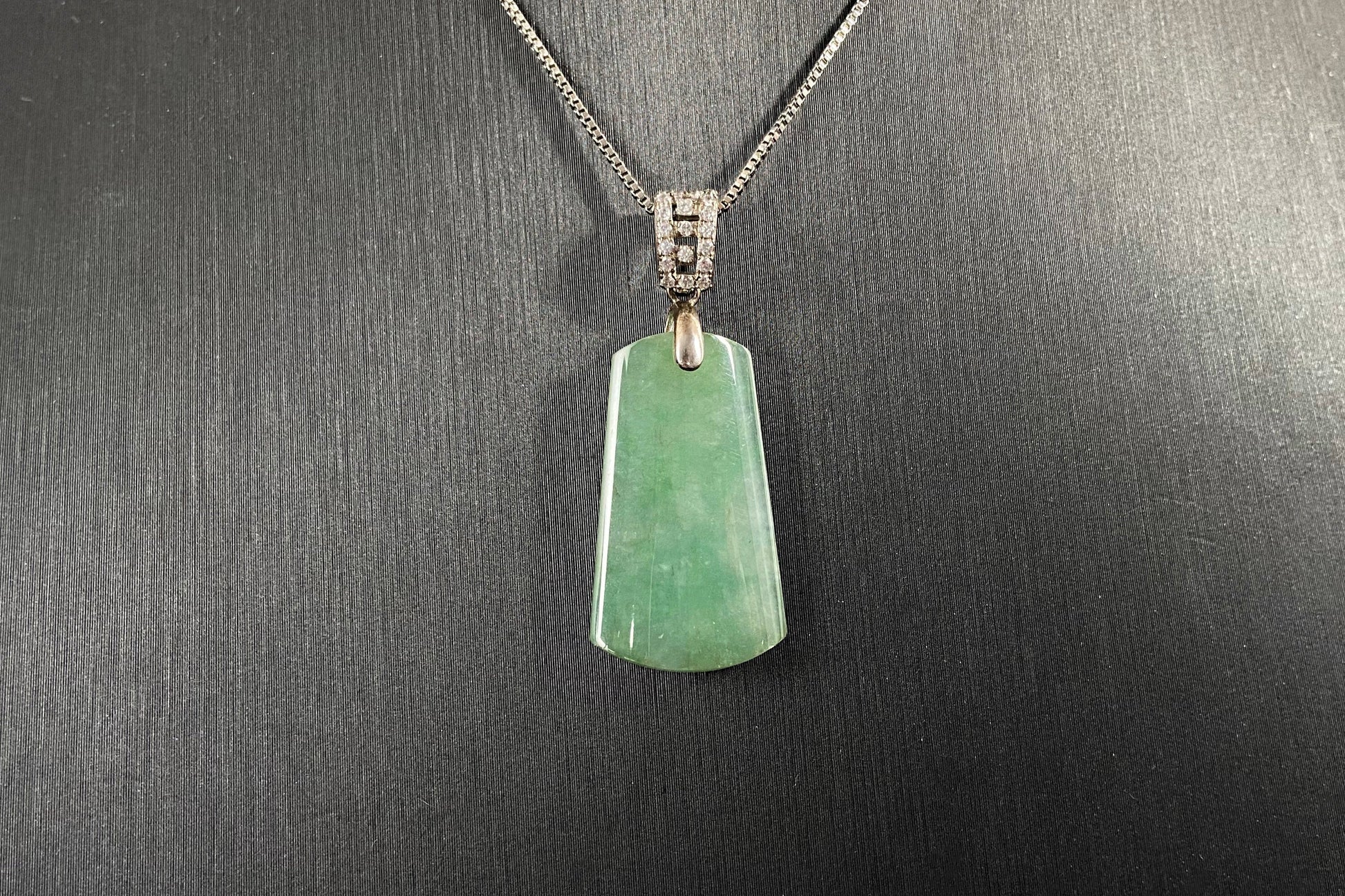 This jade pendant is a peace plaque with a green base.