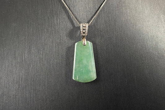 This jade pendant is a peace plaque with a green base.