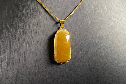 A golden yellow jade centerpiece, elegantly embraced by a gold plated 925 silver frame.