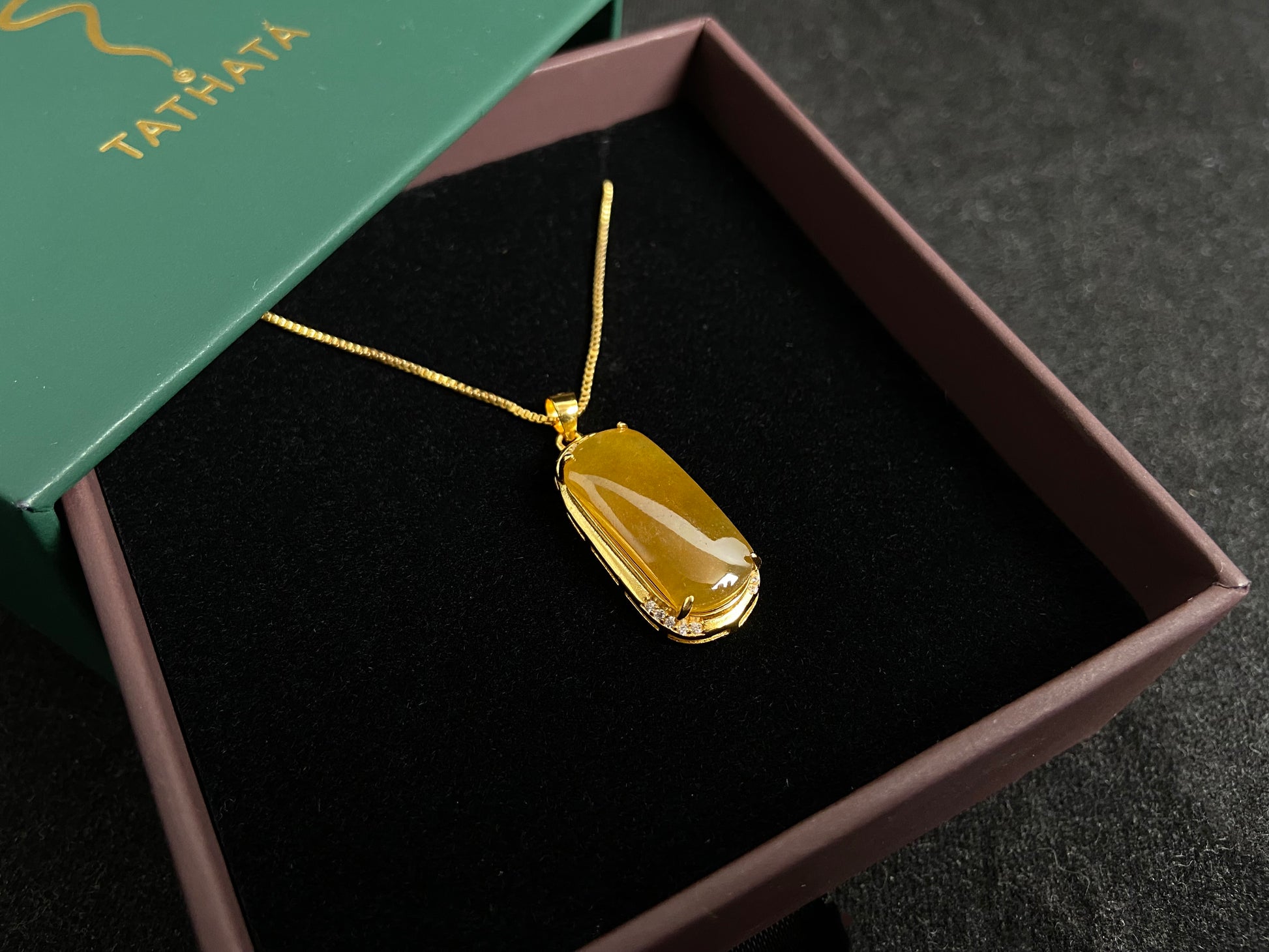 A golden yellow jade centerpiece, elegantly embraced by a gold plated 925 silver frame.