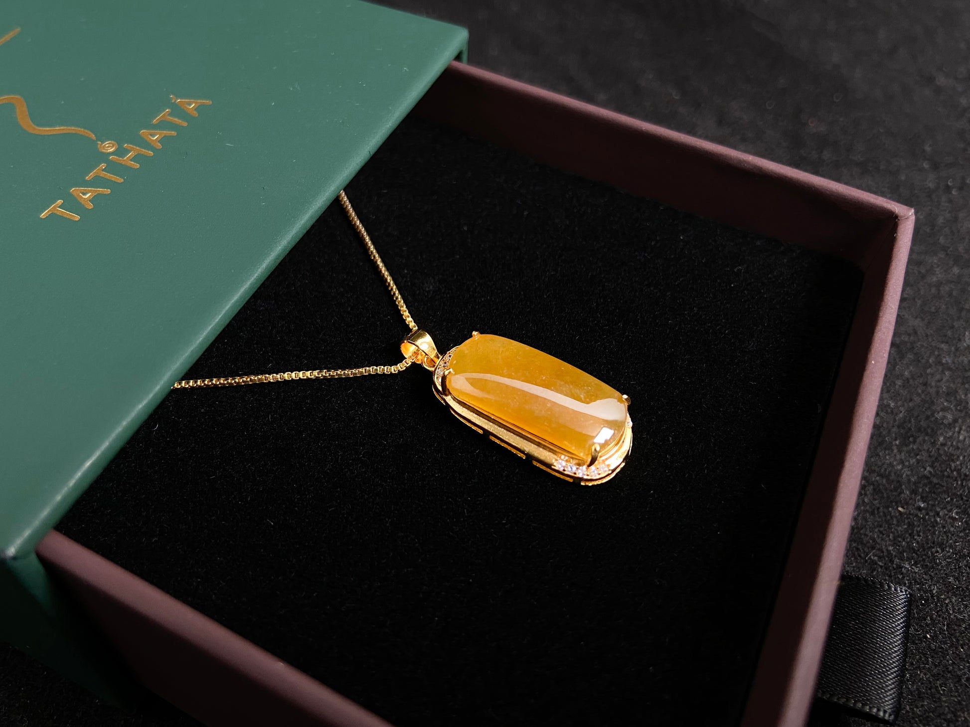 A golden yellow jade centerpiece, elegantly embraced by a gold plated 925 silver frame.