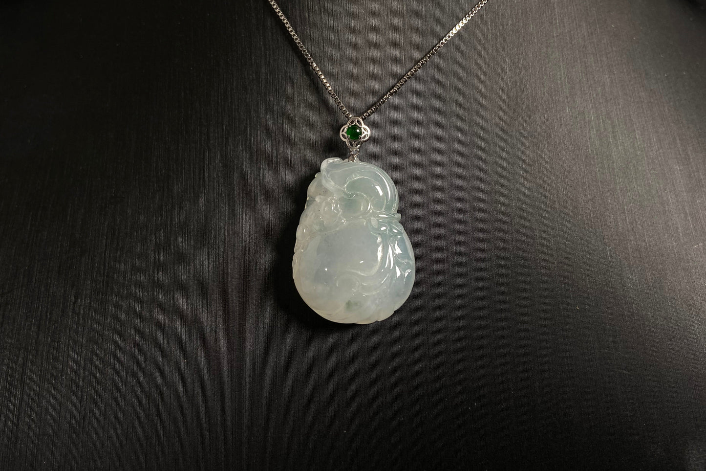 An icy jade fortune pouch pendant with floating green accents.