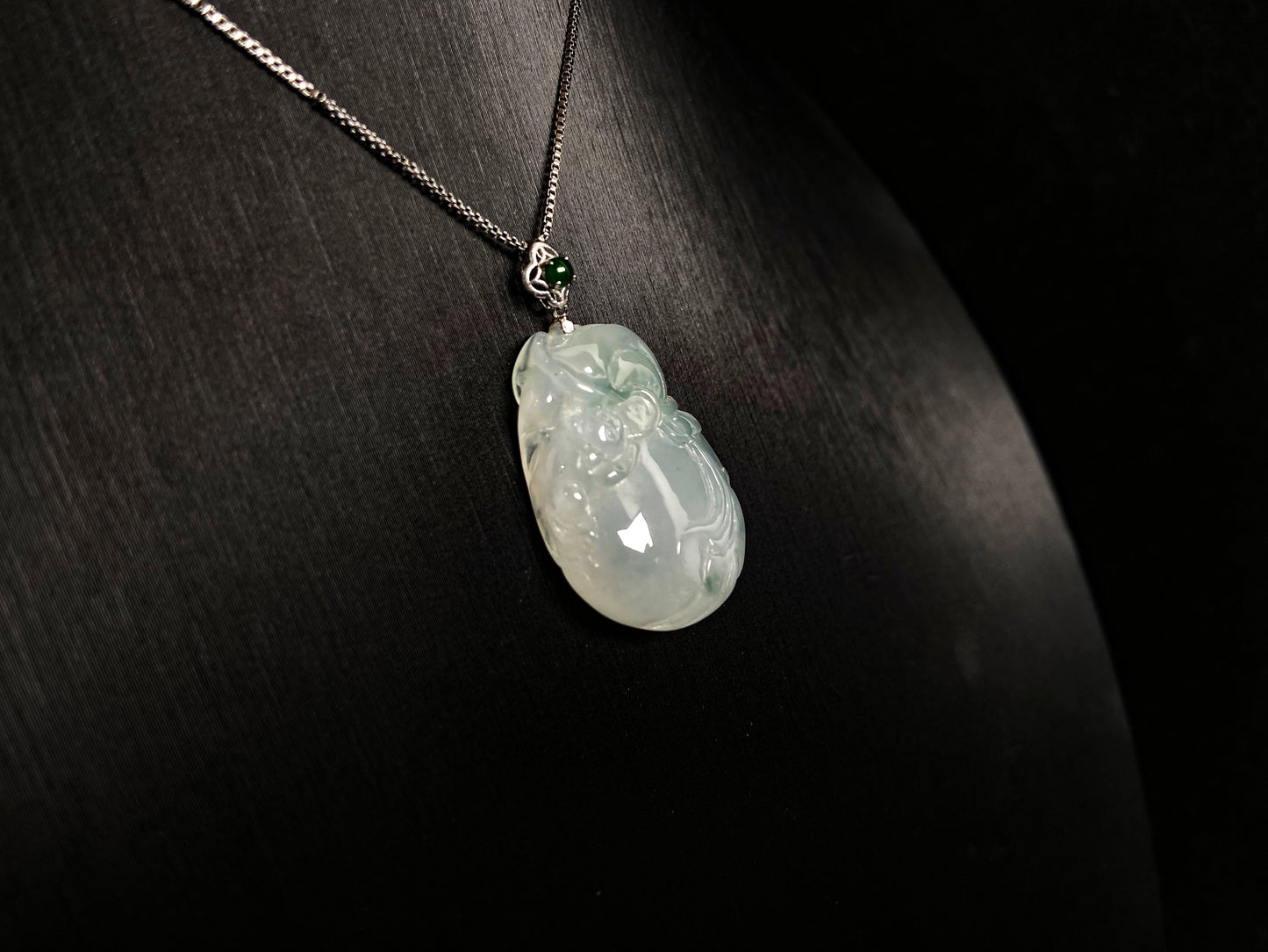 An icy jade fortune pouch pendant with floating green accents.