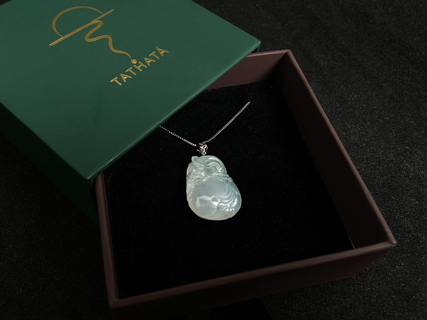 An icy jade fortune pouch pendant with floating green accents.