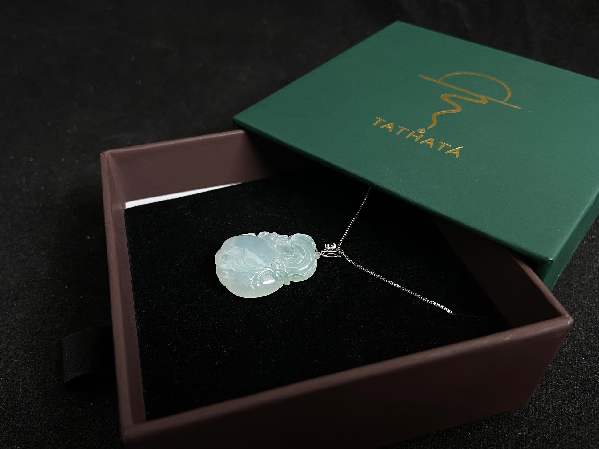 An icy jade fortune pouch pendant with floating green accents.