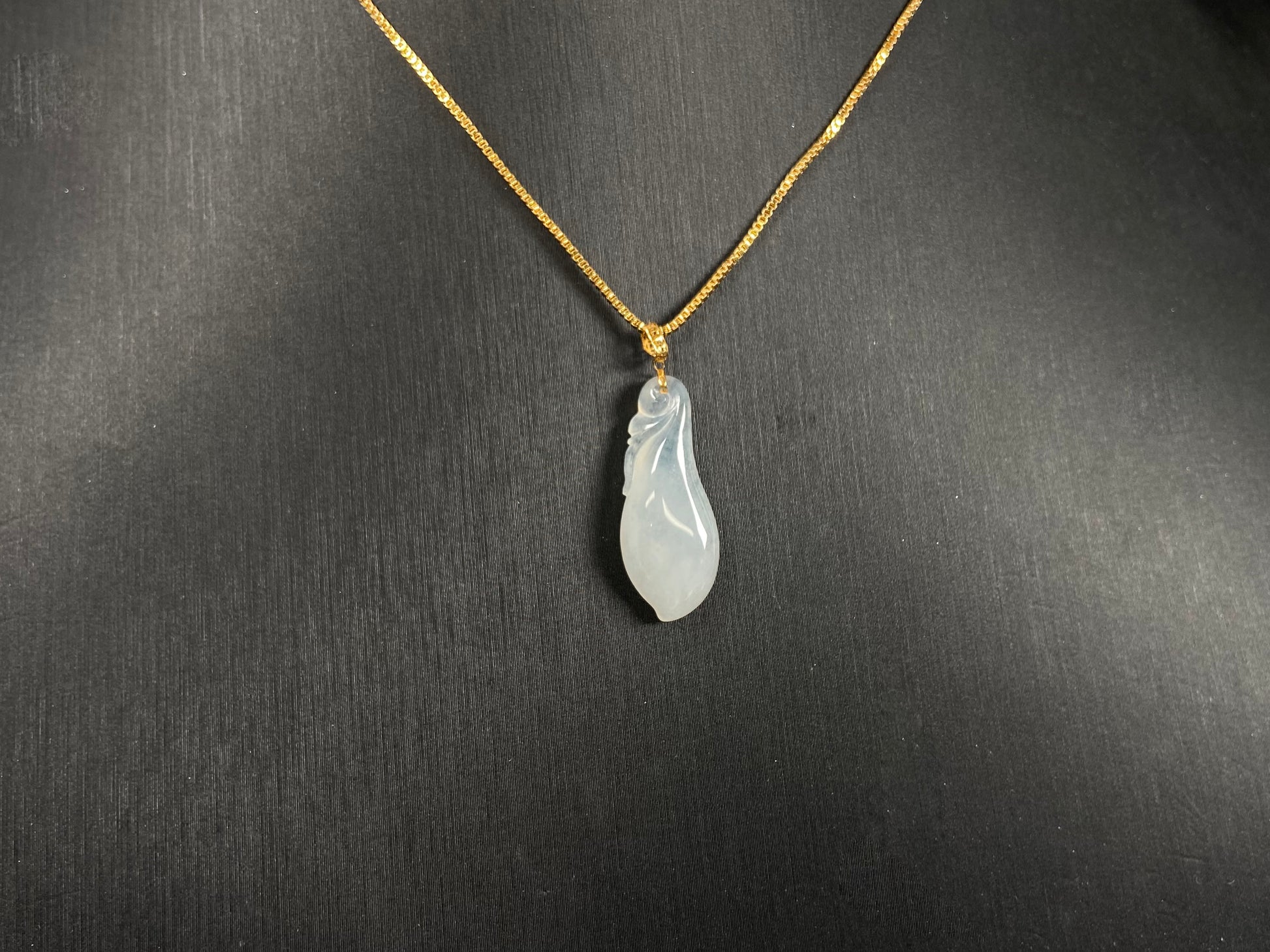 A milky white jadeite eggplant pendant.