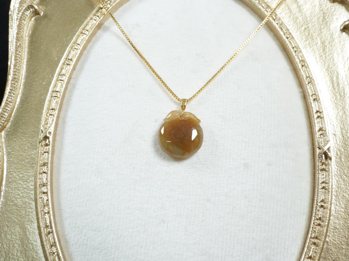 A warm amber-glazed apple Jadeite Pendant.