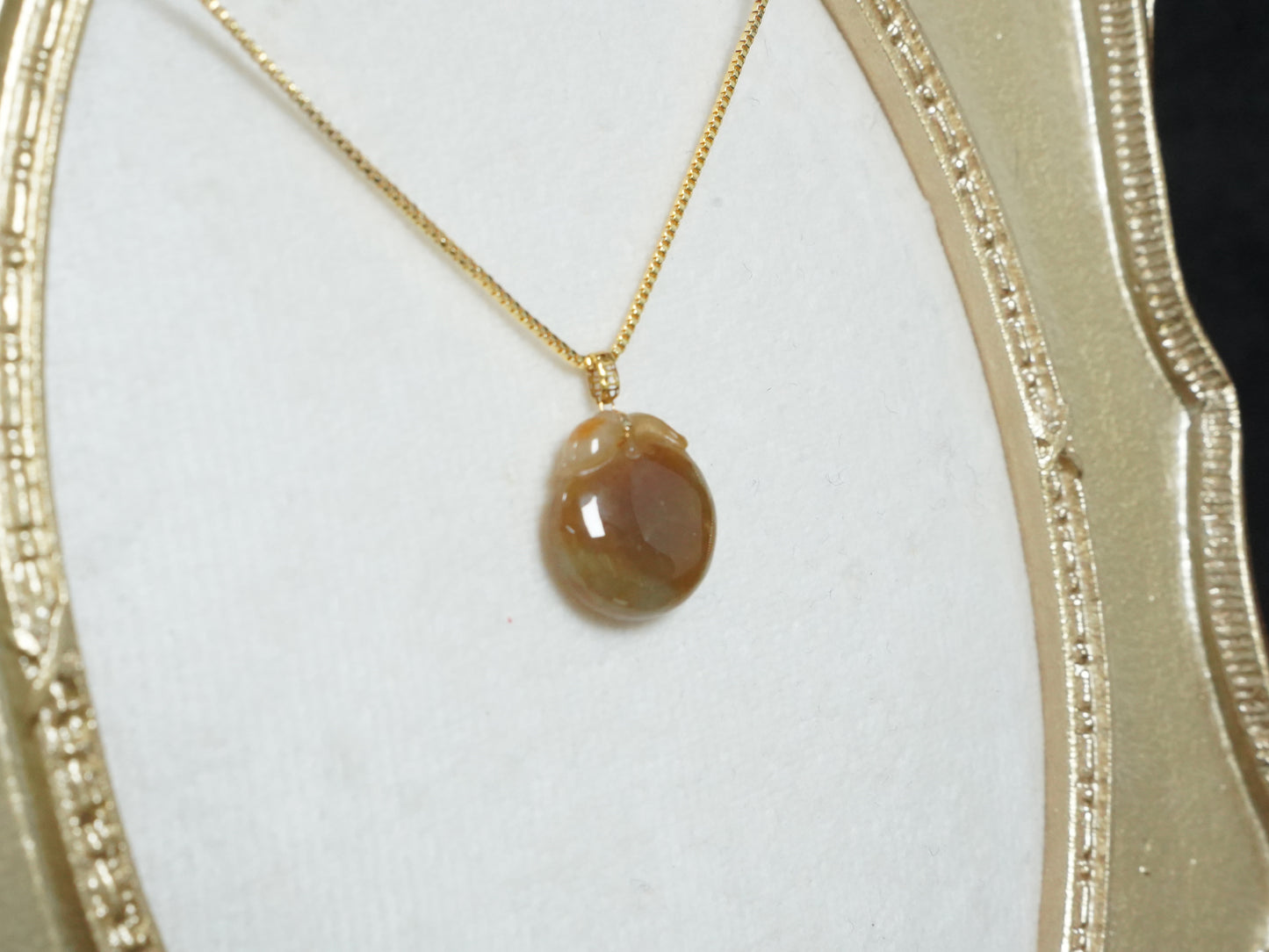 A warm amber-glazed apple Jadeite Pendant.