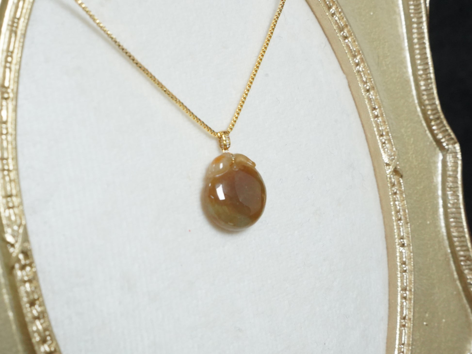 A warm amber-glazed apple Jadeite Pendant.