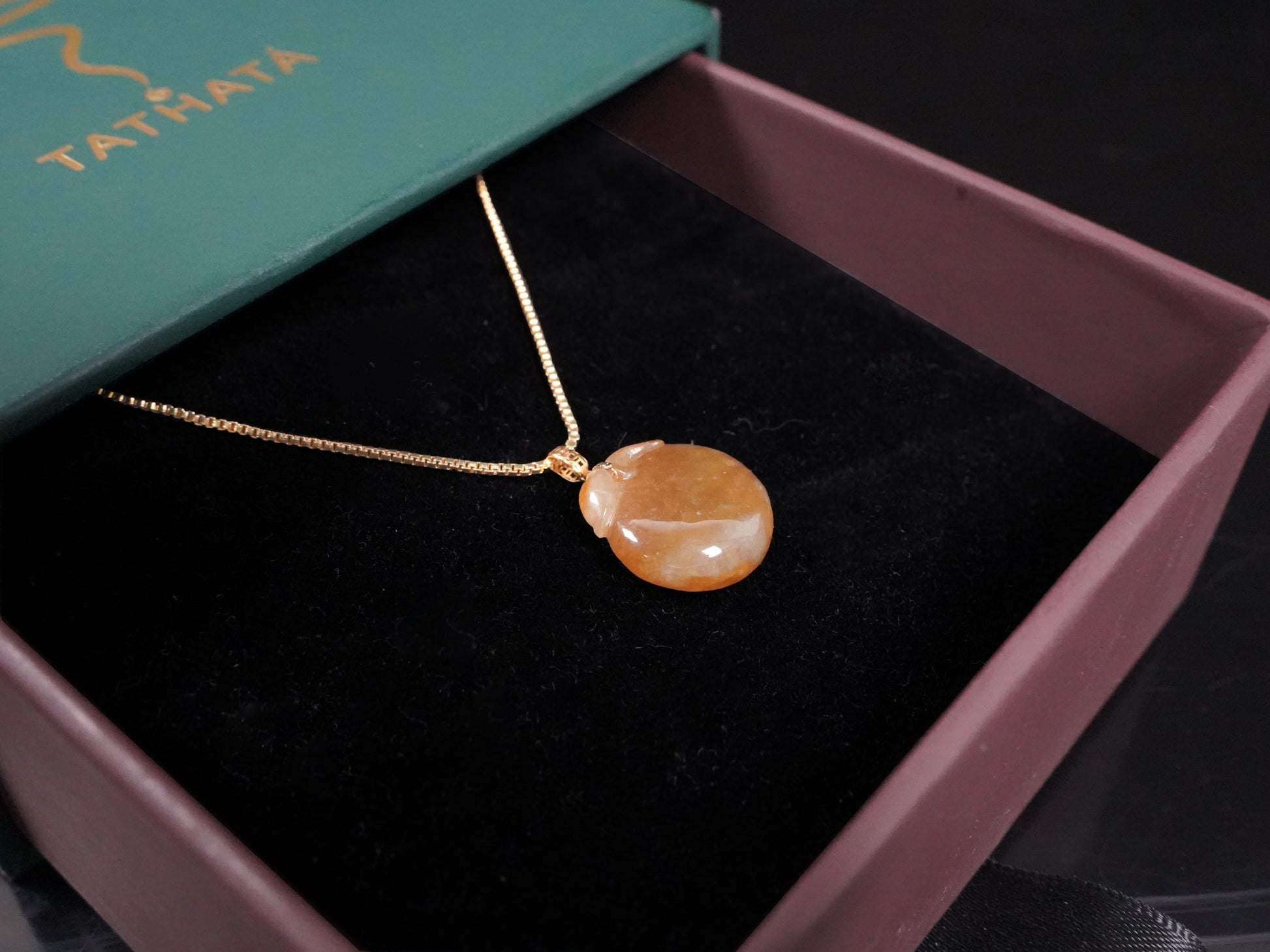 A warm amber-glazed apple Jadeite Pendant.