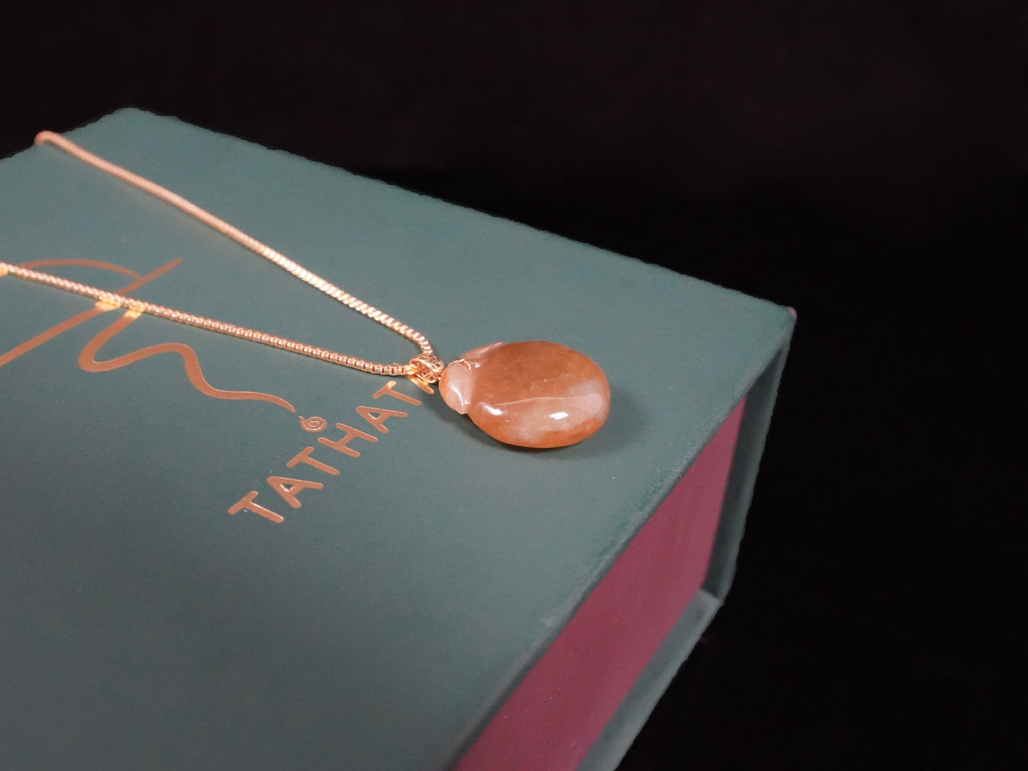 A warm amber-glazed apple Jadeite Pendant.