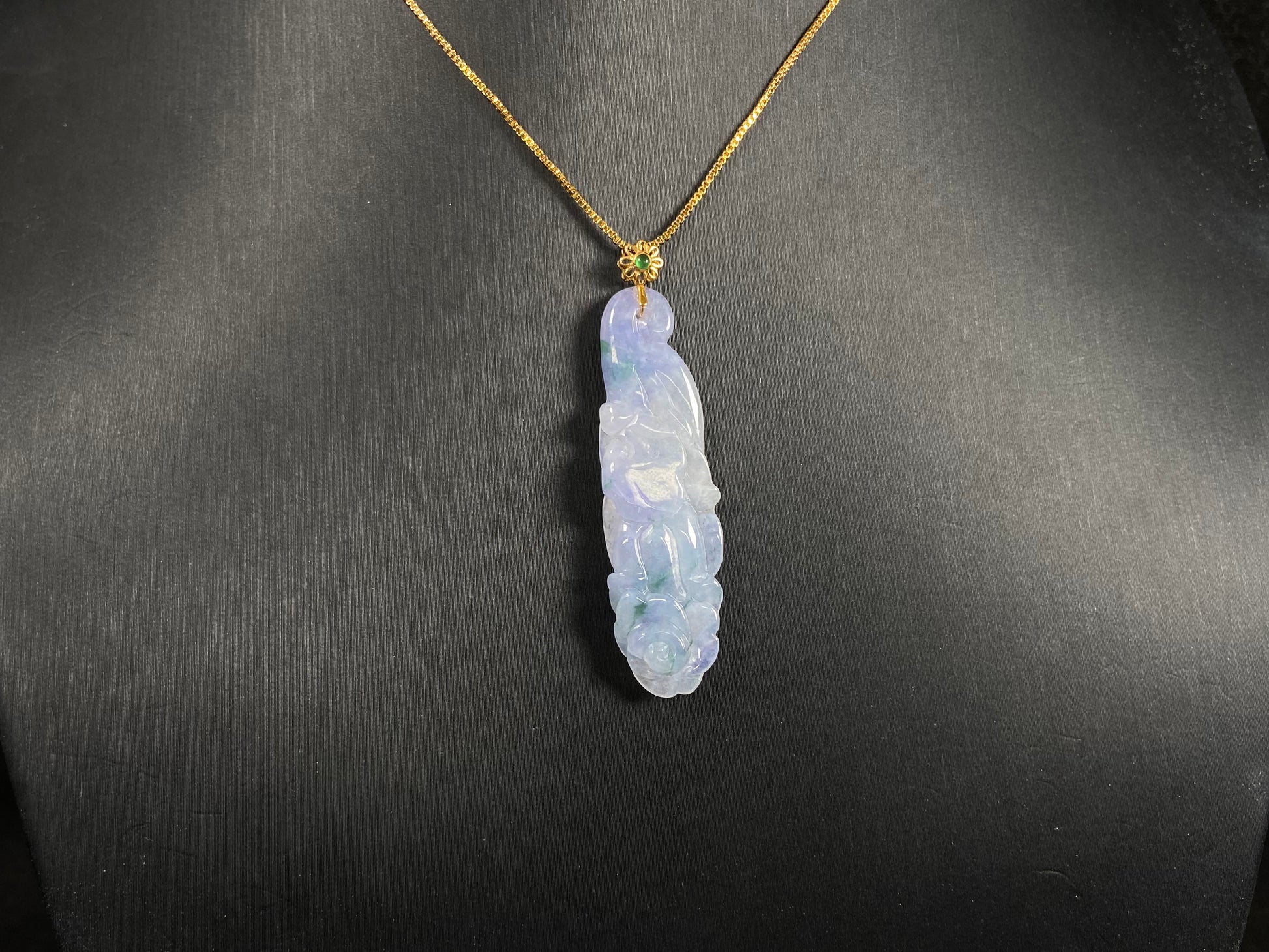 This pendant features a white and purple jadeite flower with hints of green.