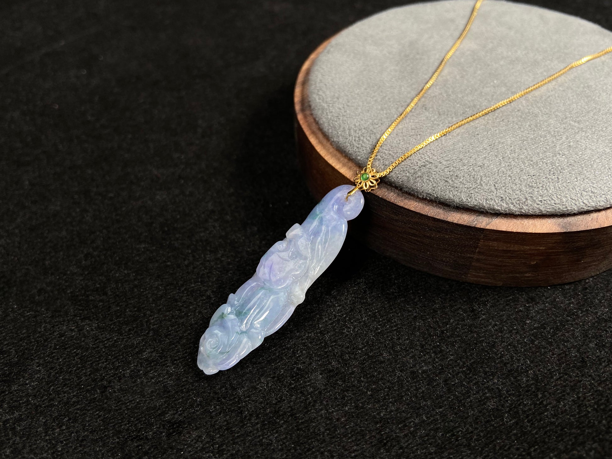 This pendant features a white and purple jadeite flower with hints of green.