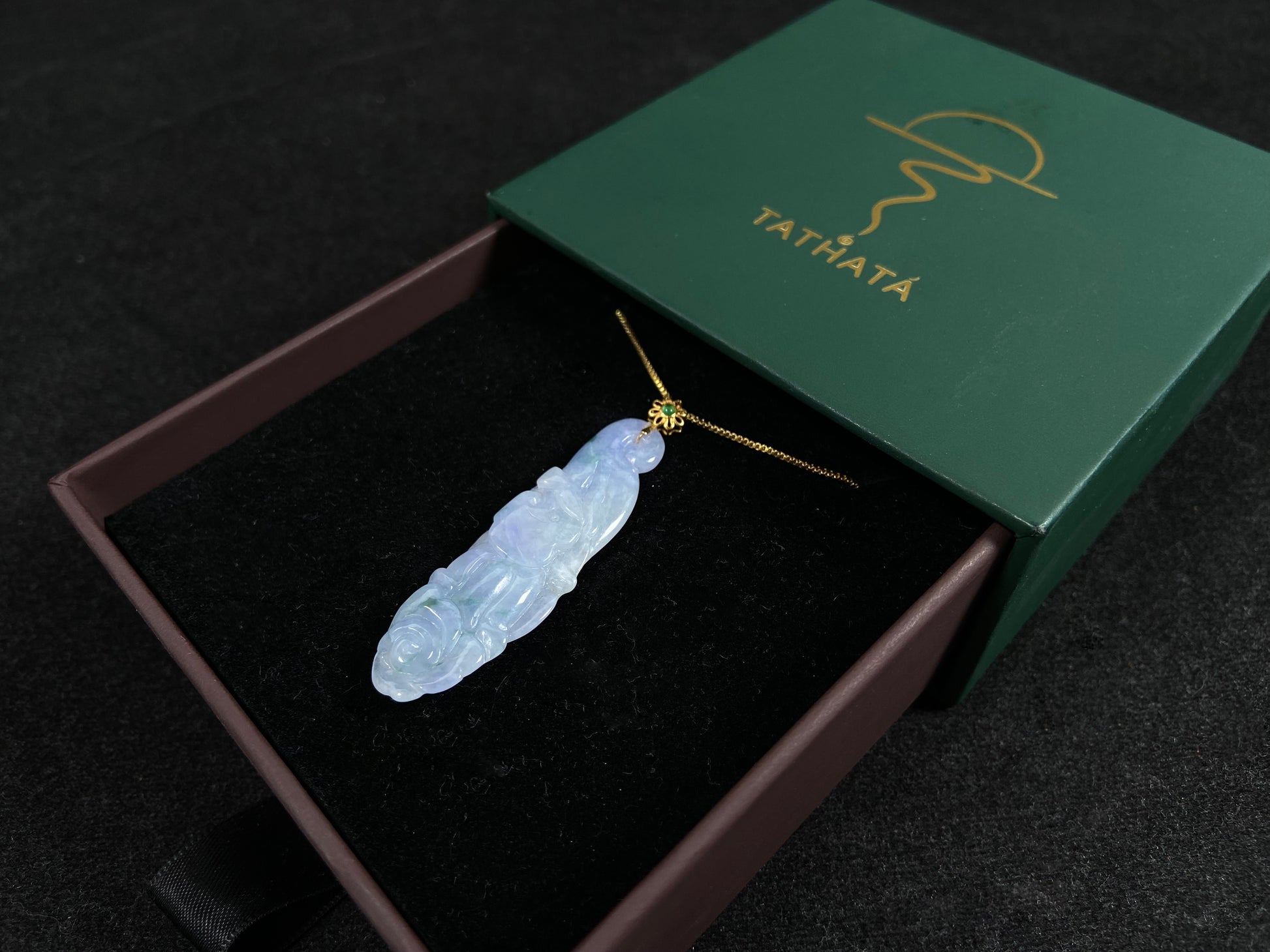 This pendant features a white and purple jadeite flower with hints of green.