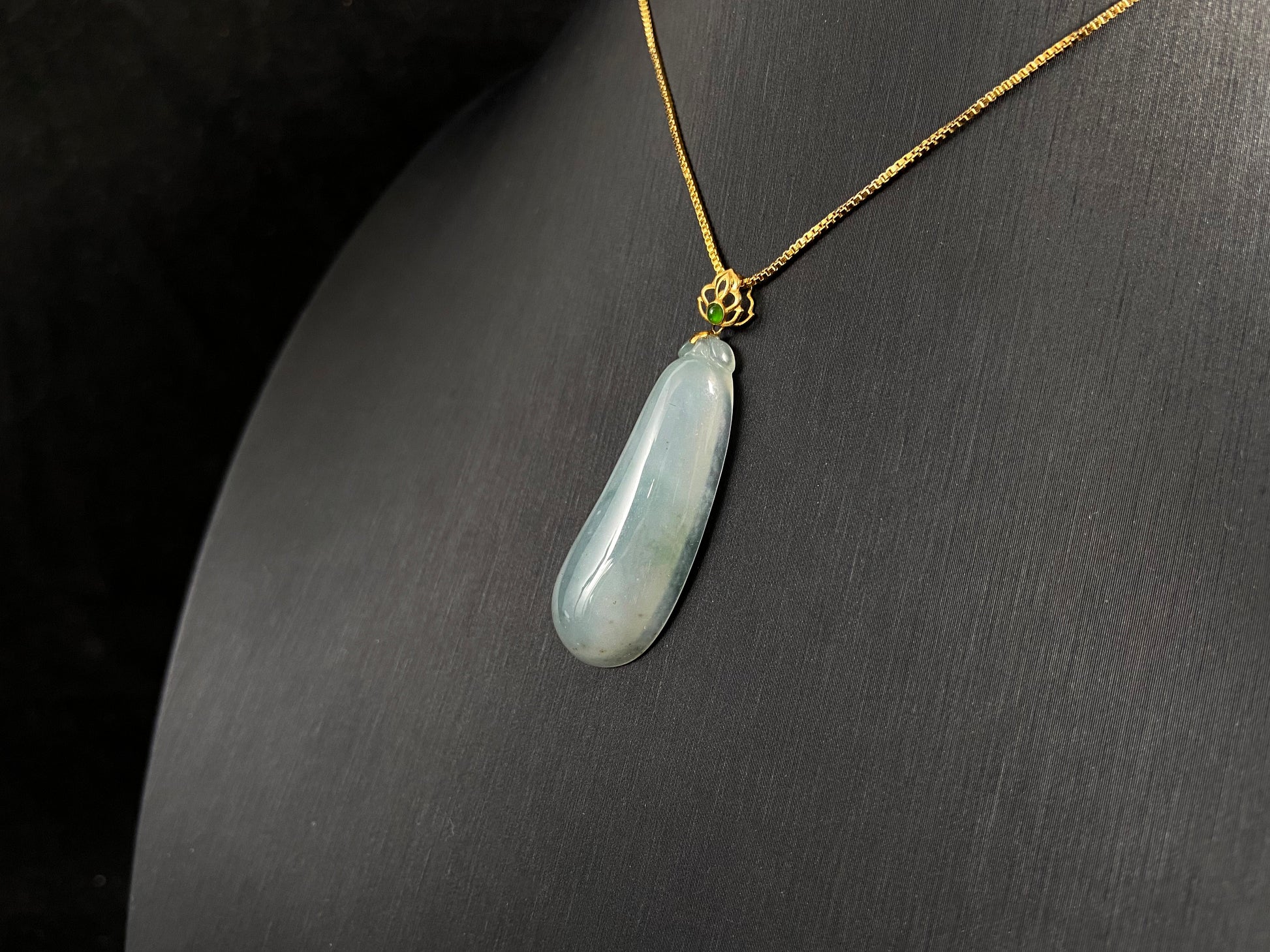 A pendant carved from translucent white jade into the form of a melon a Chinese symbol of good fortune.