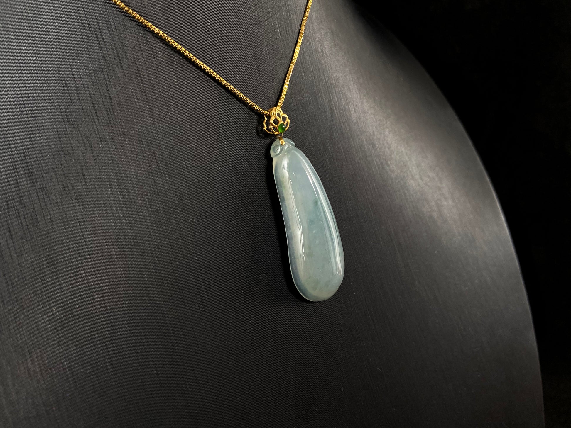 A pendant carved from translucent white jade into the form of a melon a Chinese symbol of good fortune.