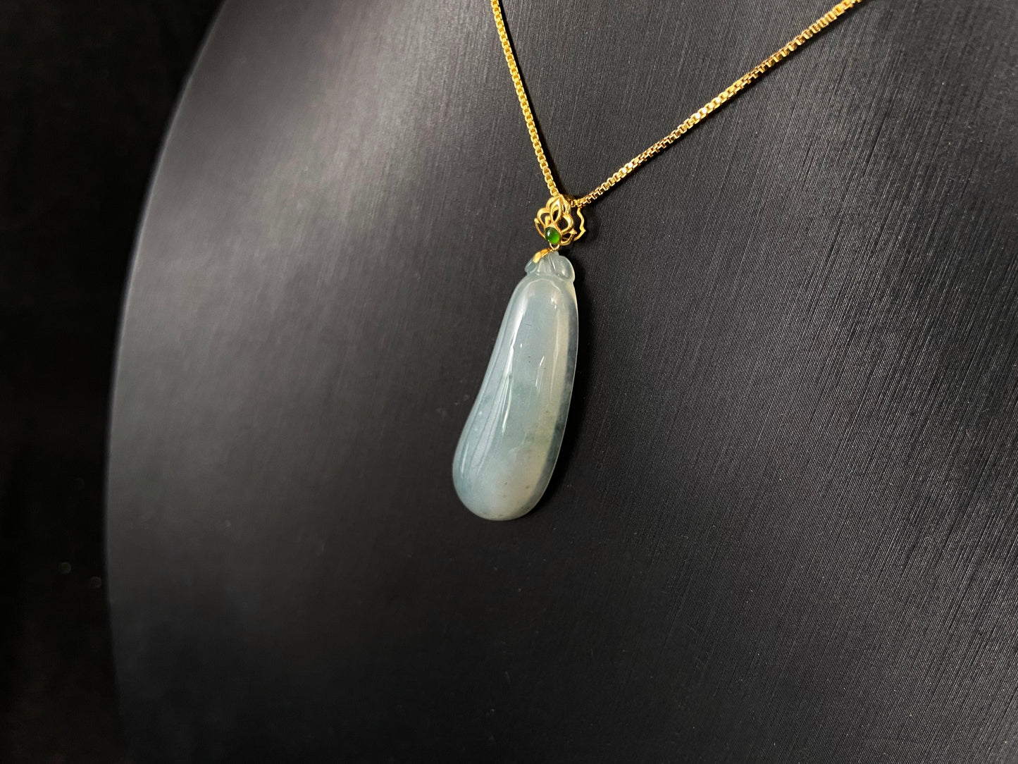 A pendant carved from translucent white jade into the form of a melon a Chinese symbol of good fortune.