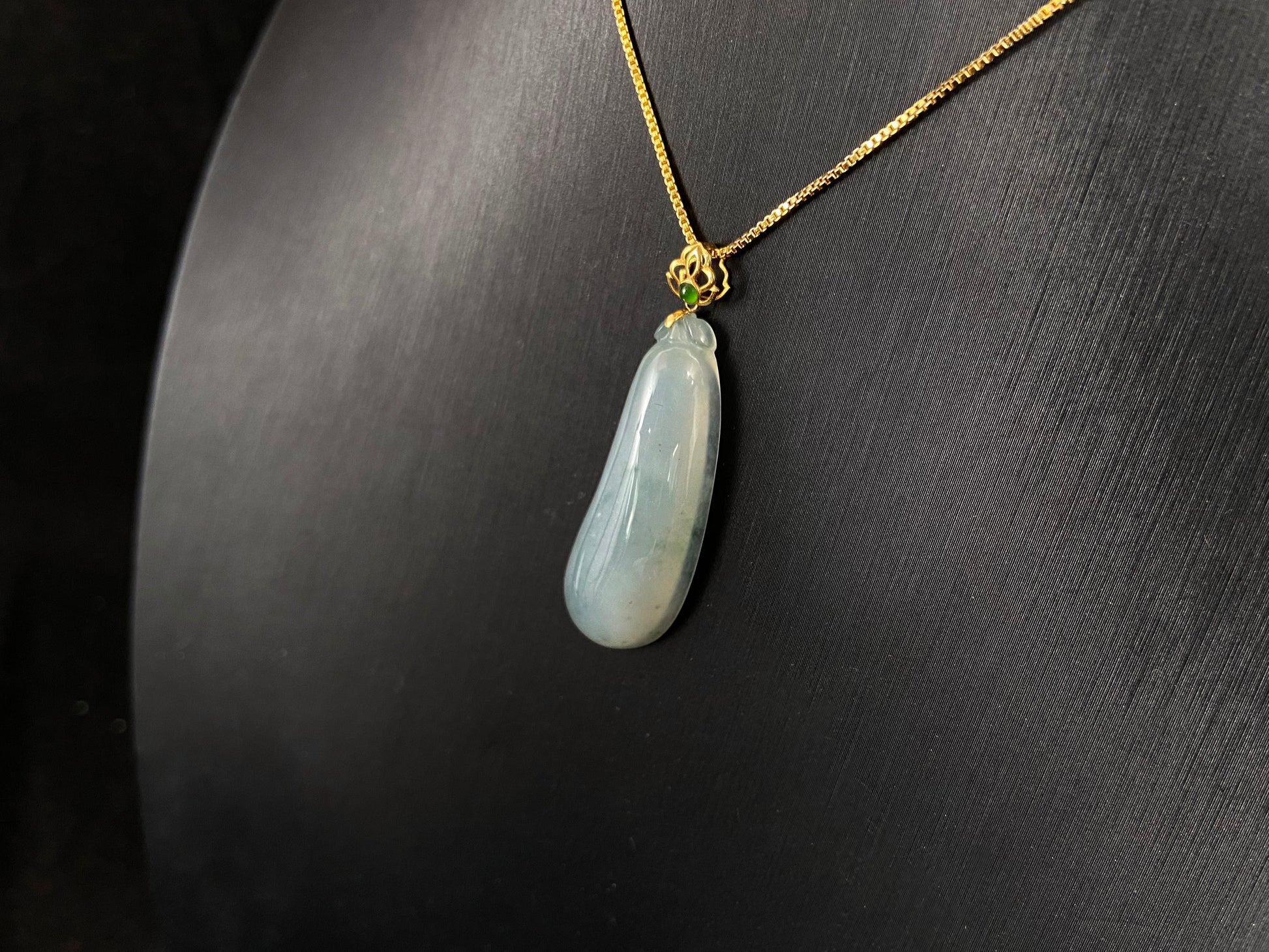 A pendant carved from translucent white jade into the form of a melon a Chinese symbol of good fortune.