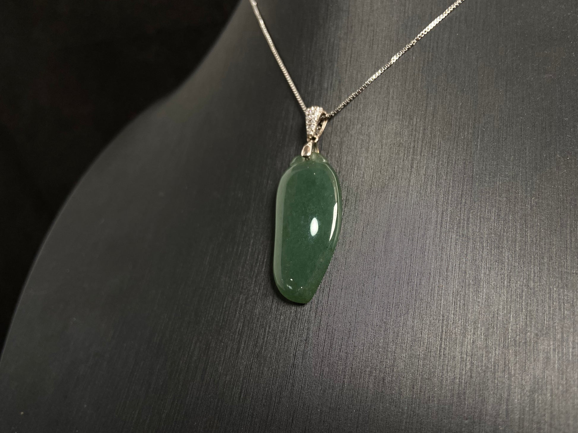 A deep green jade "Fortune Melon" pendant, symbolizing abundance and blessings.
