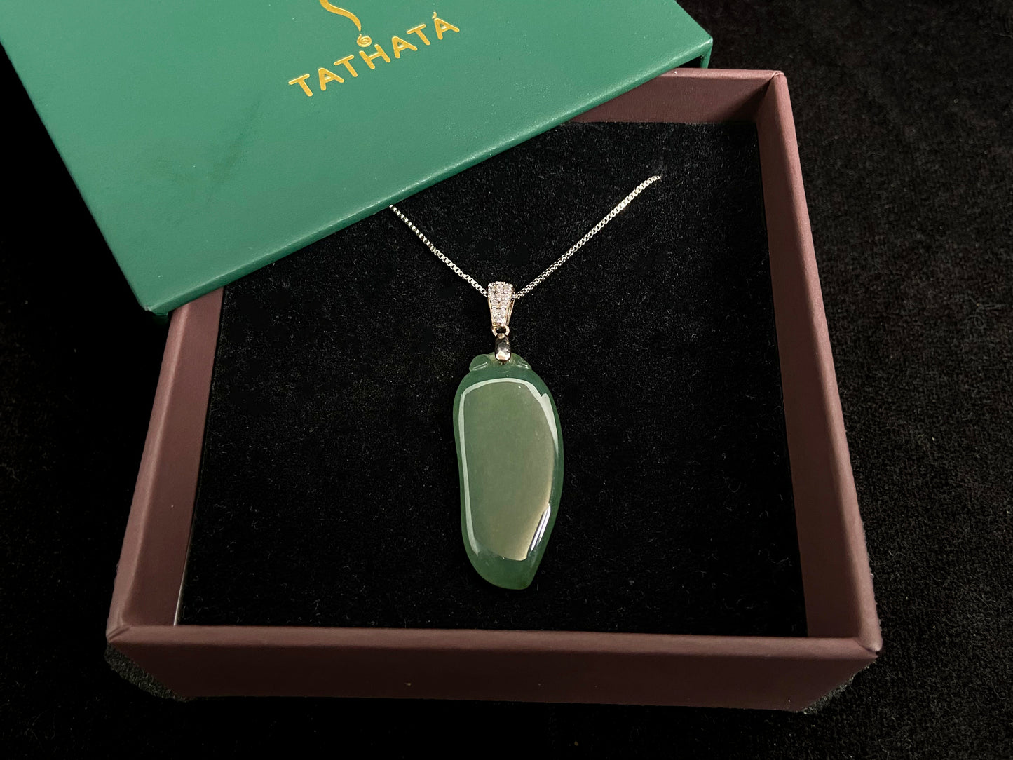A deep green jade "Fortune Melon" pendant, symbolizing abundance and blessings.