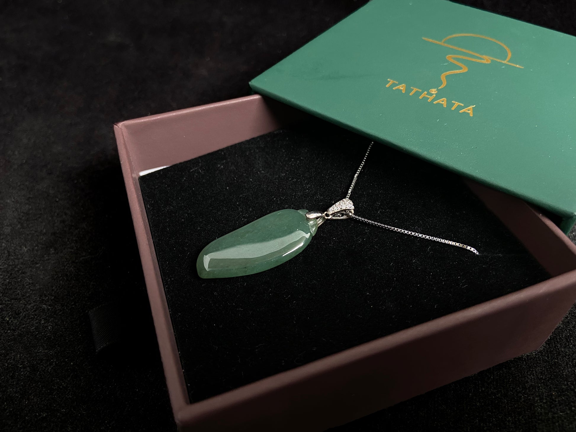 A deep green jade "Fortune Melon" pendant, symbolizing abundance and blessings.