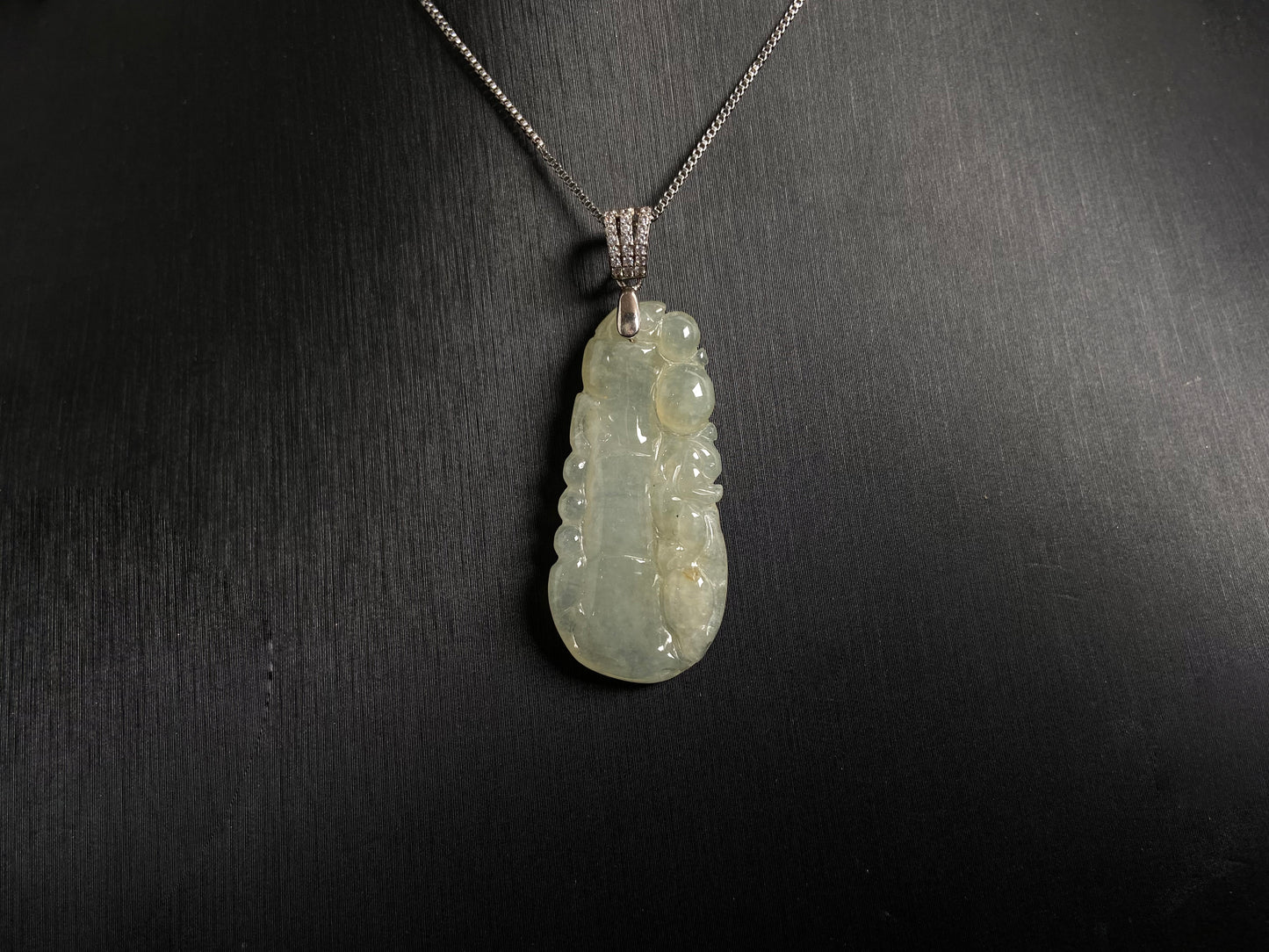 A translucent white jade bamboo pendant with a subtle golden glow.