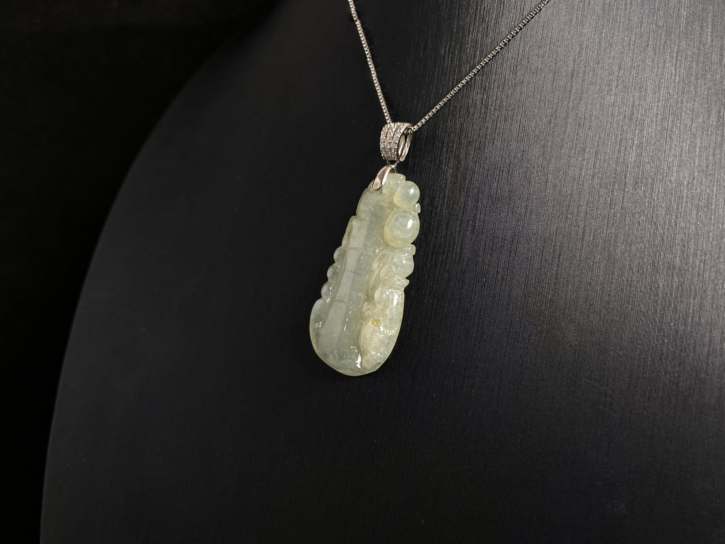 A translucent white jade bamboo pendant with a subtle golden glow.