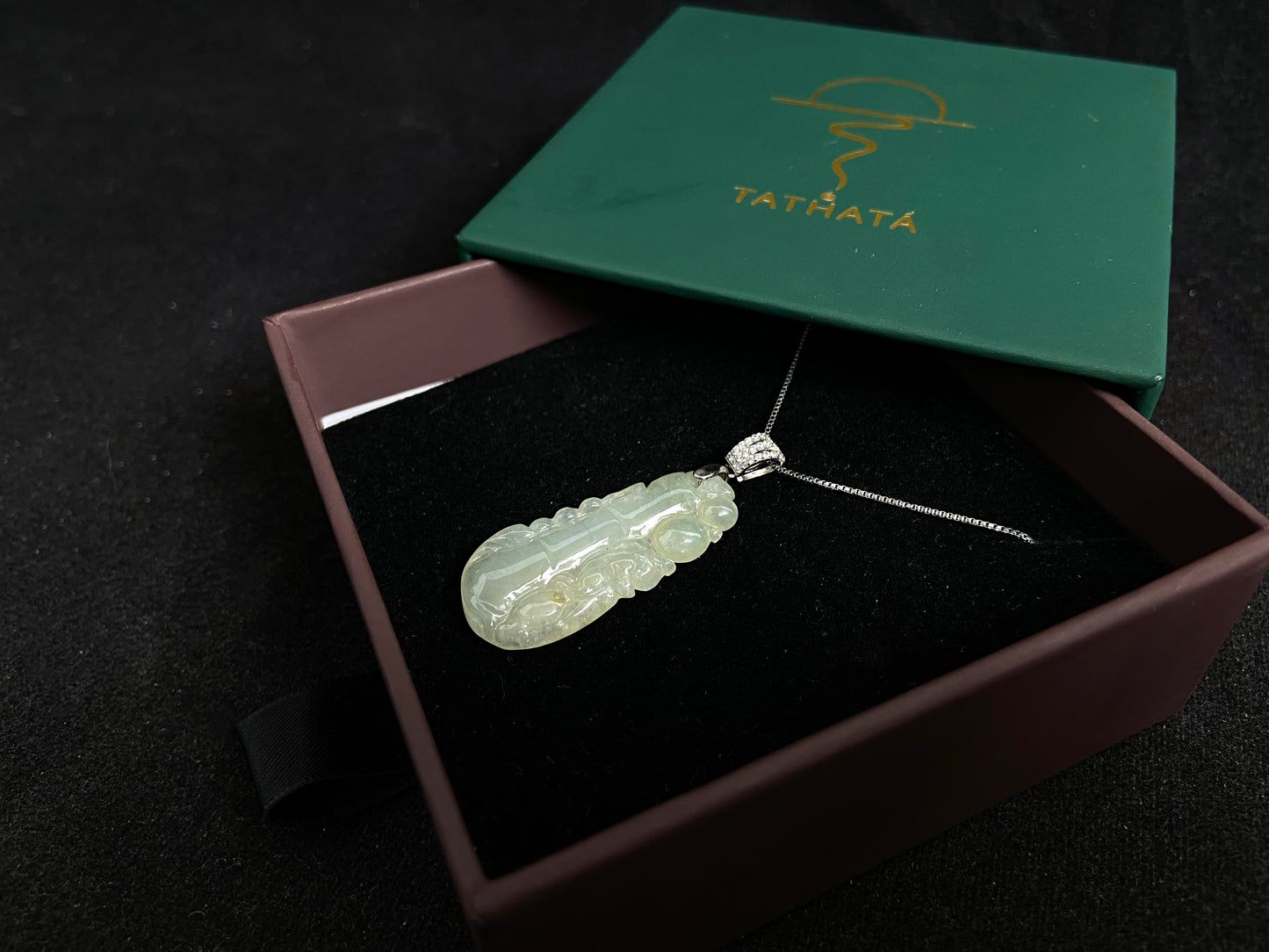 A translucent white jade bamboo pendant with a subtle golden glow.