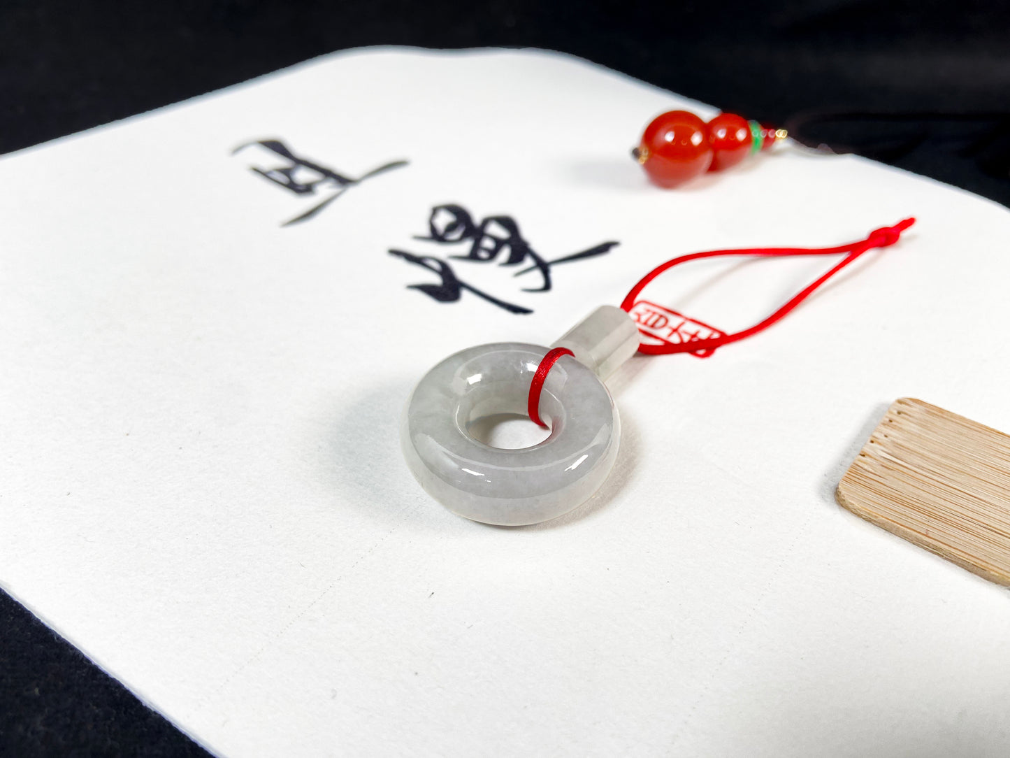 A milky white jadeite "Lu Lu Tong" pendant.