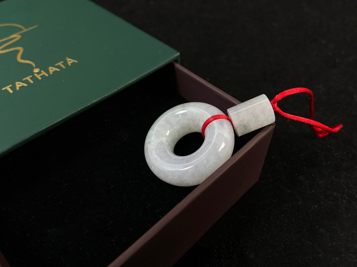 A milky white jadeite "Lu Lu Tong" pendant.