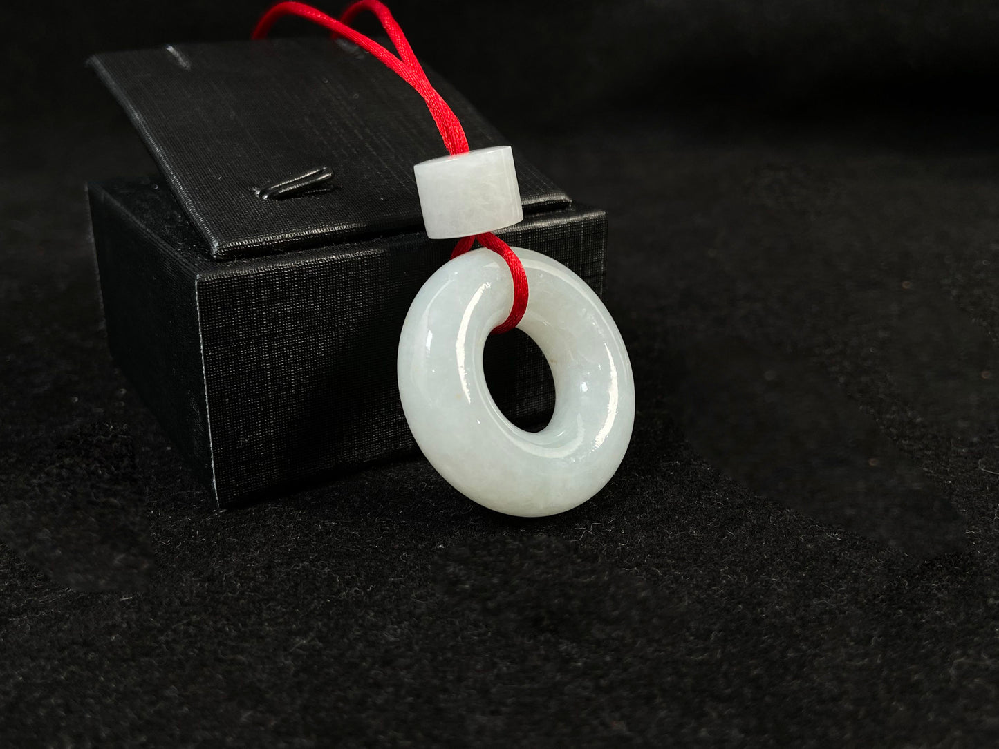 A creamy white jade pendant shaped as a peace ring.