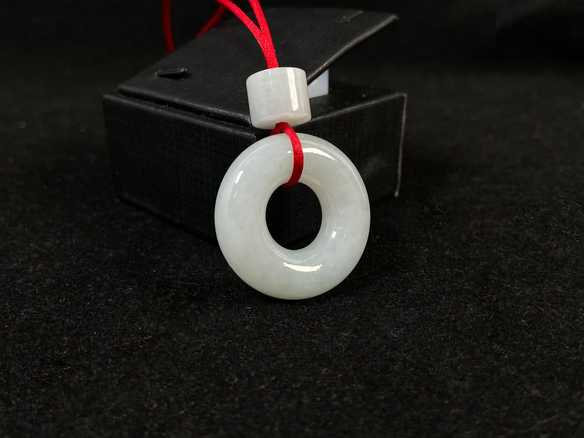 A creamy white jade pendant shaped as a peace ring.