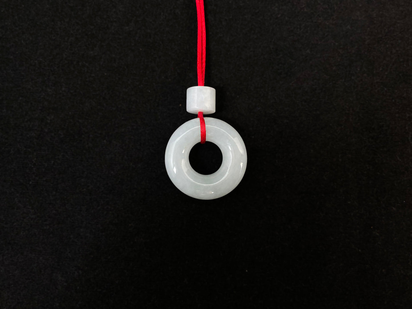 A creamy white jade pendant shaped as a peace ring.