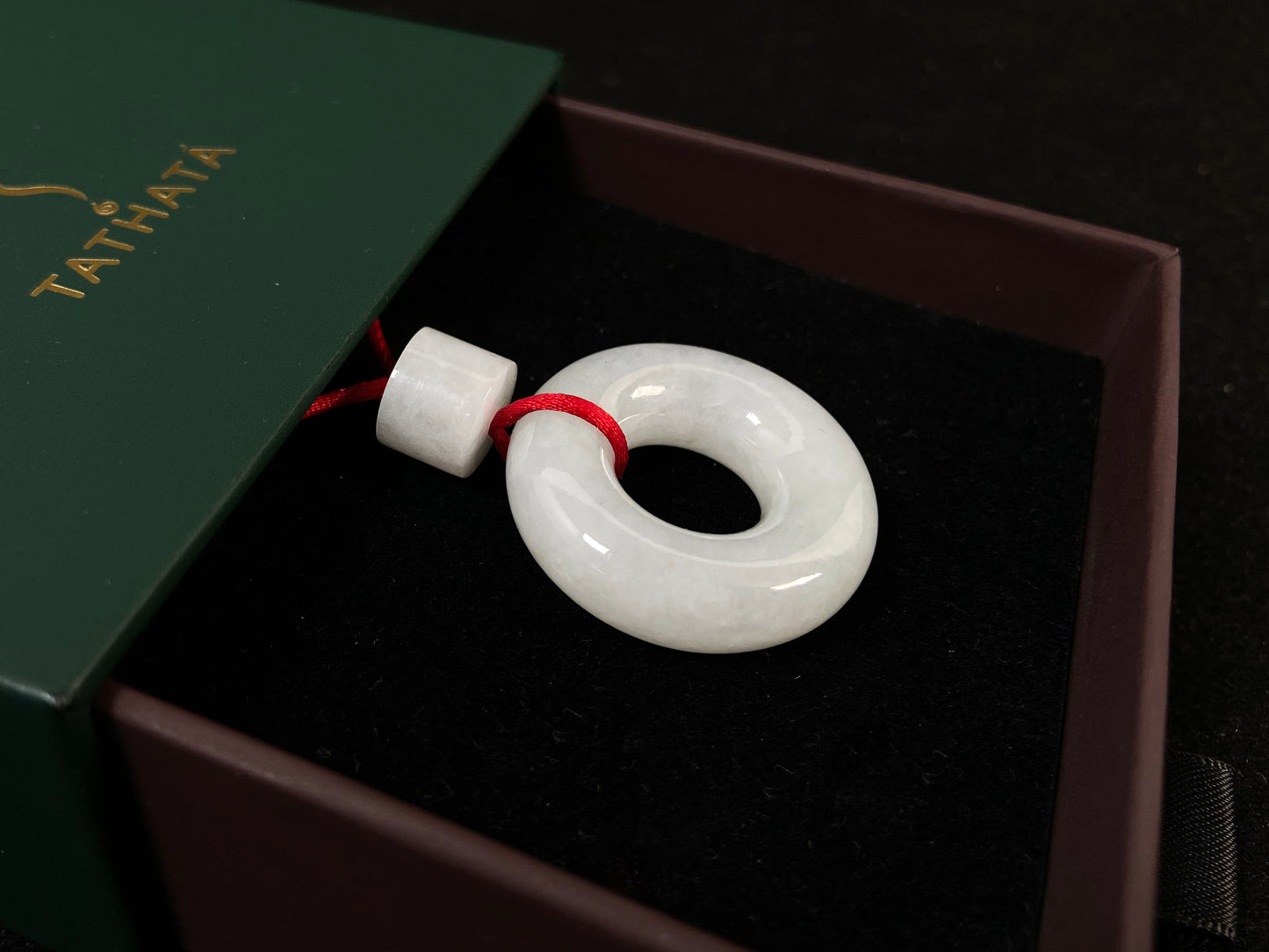 A creamy white jade pendant shaped as a peace ring.