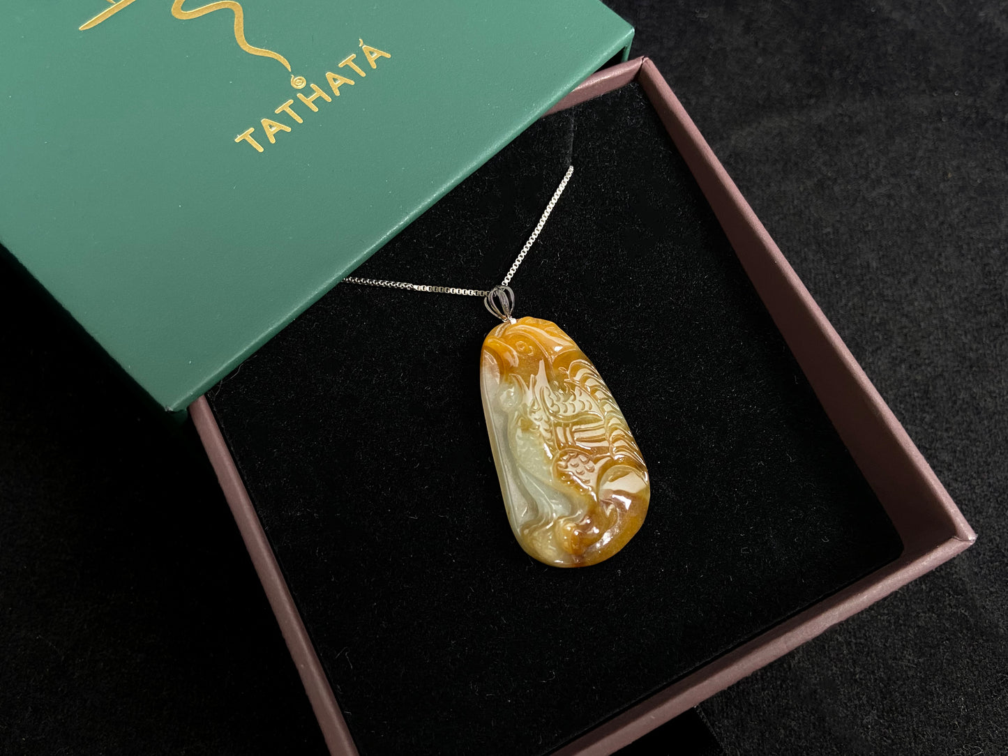 This jade pendant features a phoenix design in warm brown tones with subtle white accents, symbolizing nobility and good fortune.